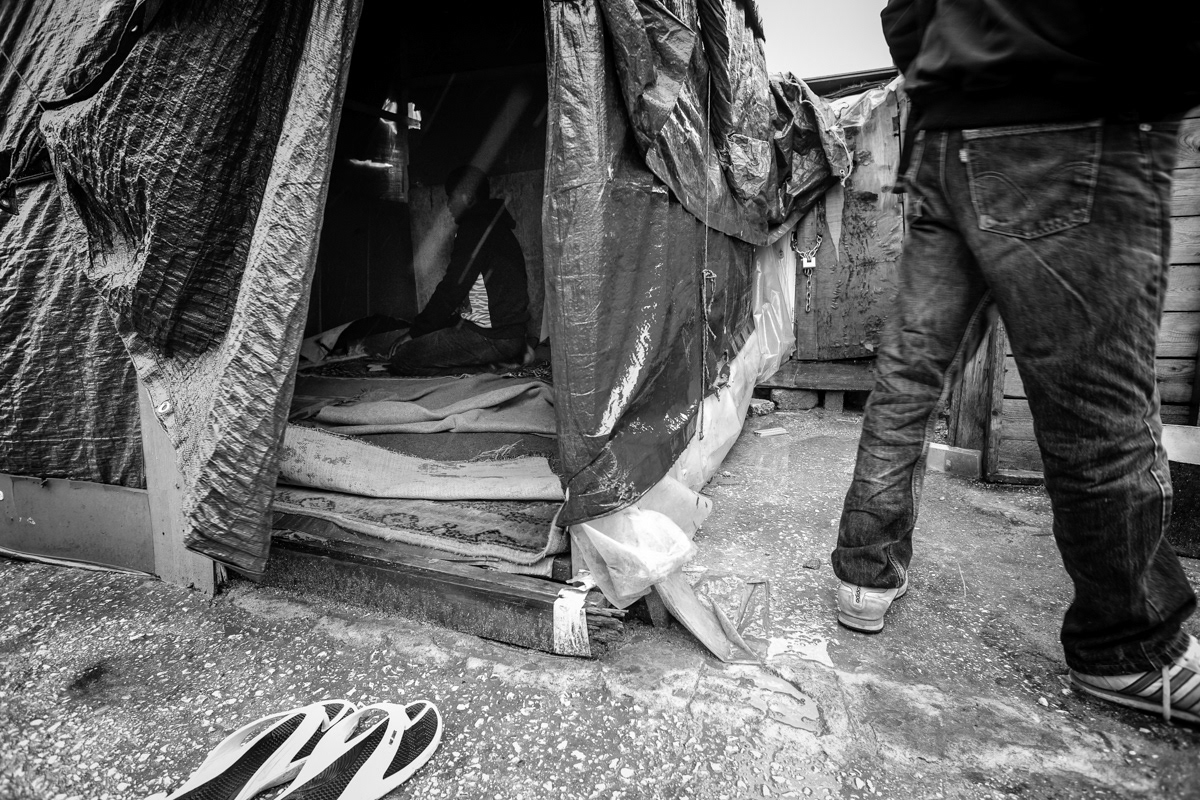 Homeless farm worker from Gambia is praying in mosque located in the informal camp