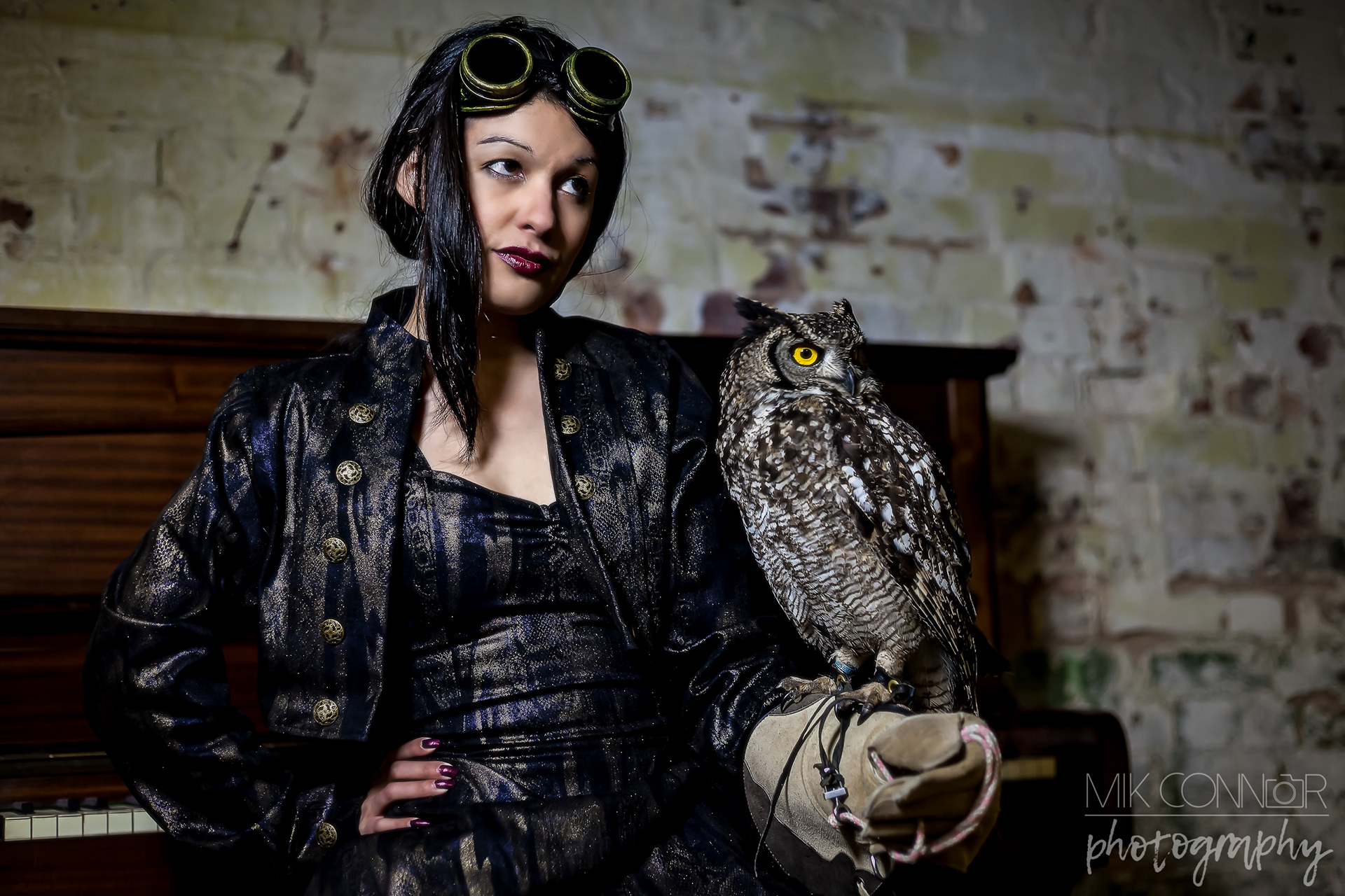 Portrait of a female model in a steampunk costume posing holding an owl