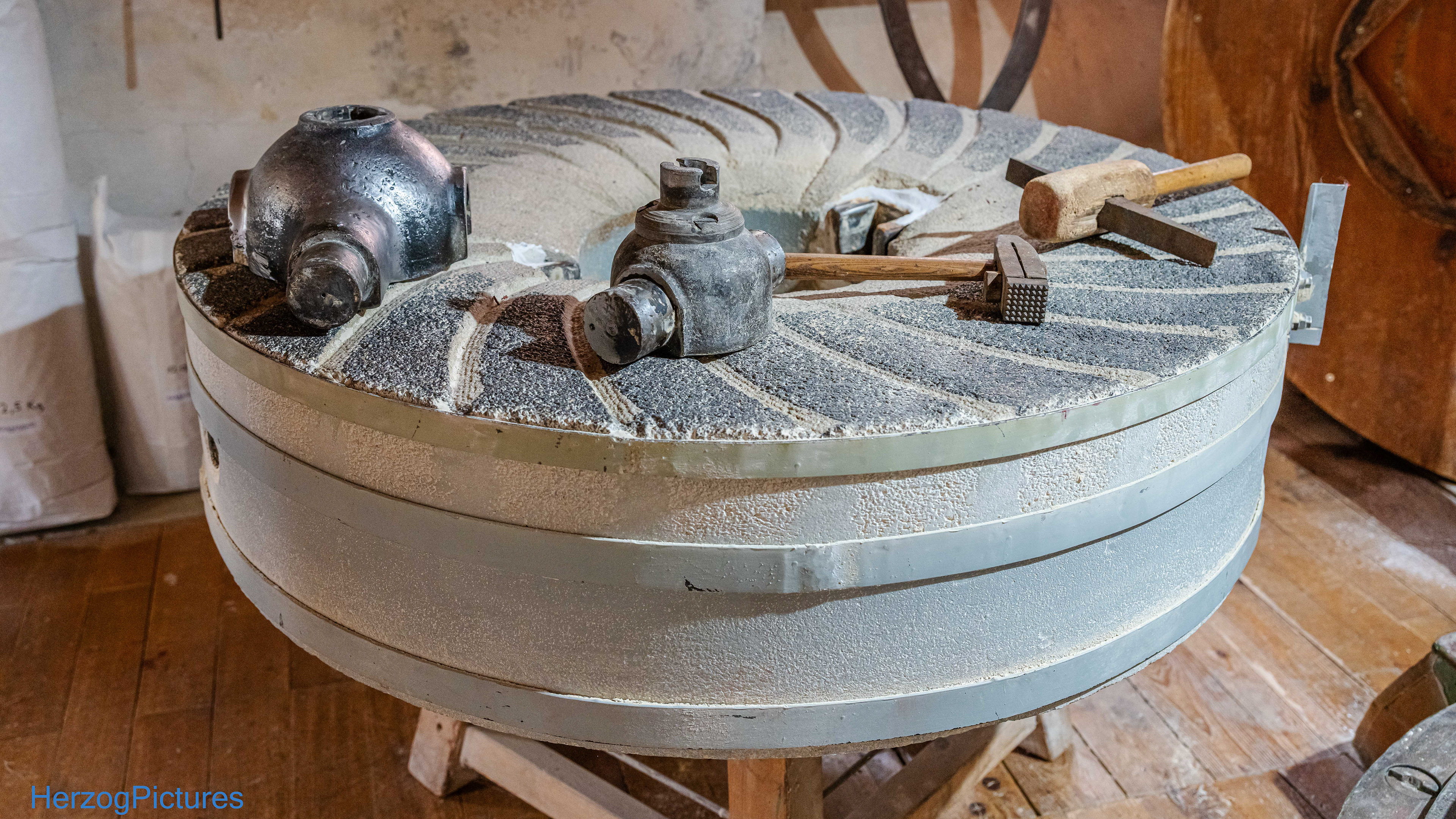 Läuferstein (obere Scheibe) – rotiert horizontal über dem Bodenstein.