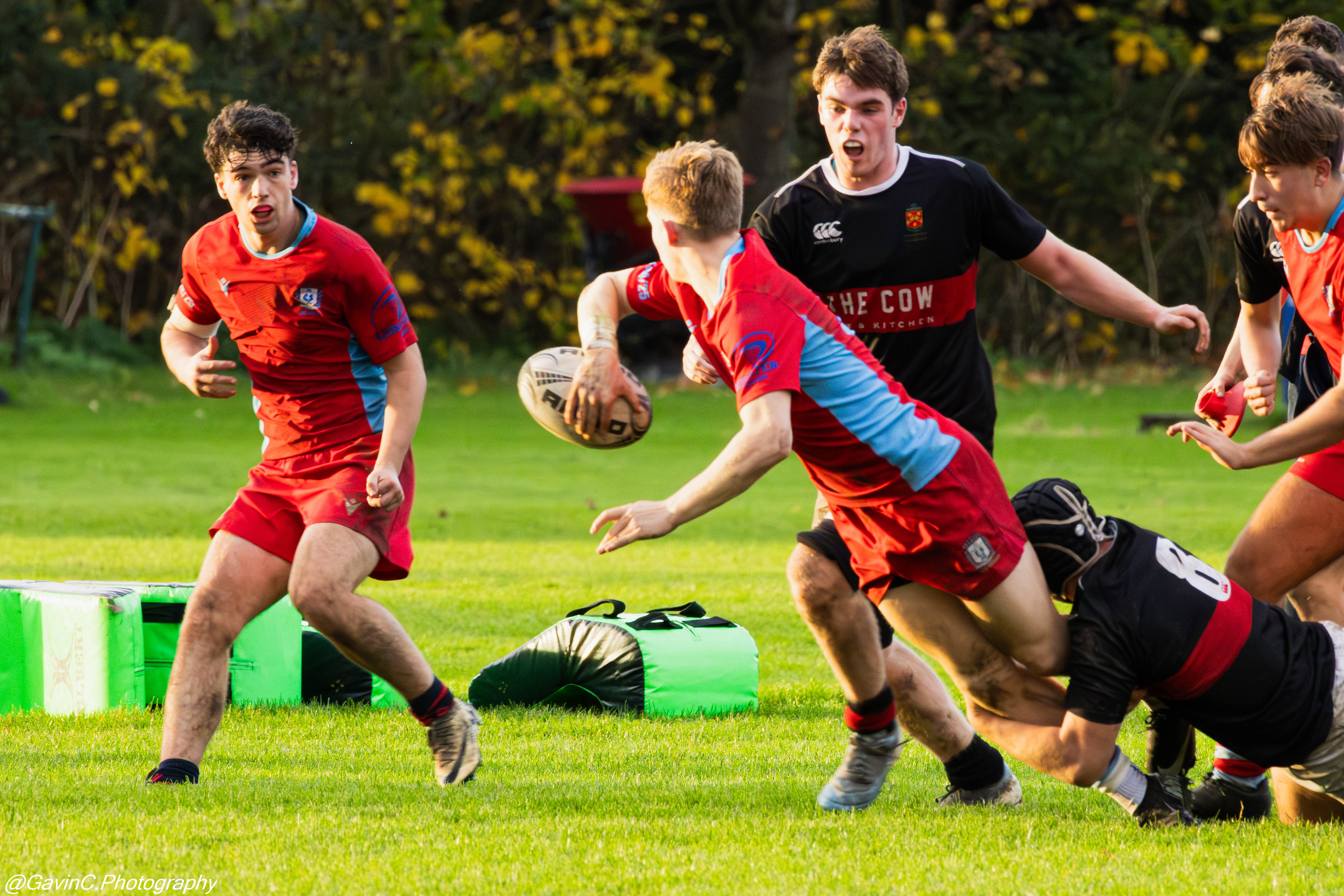 CUS player offloading the ball while being tackled