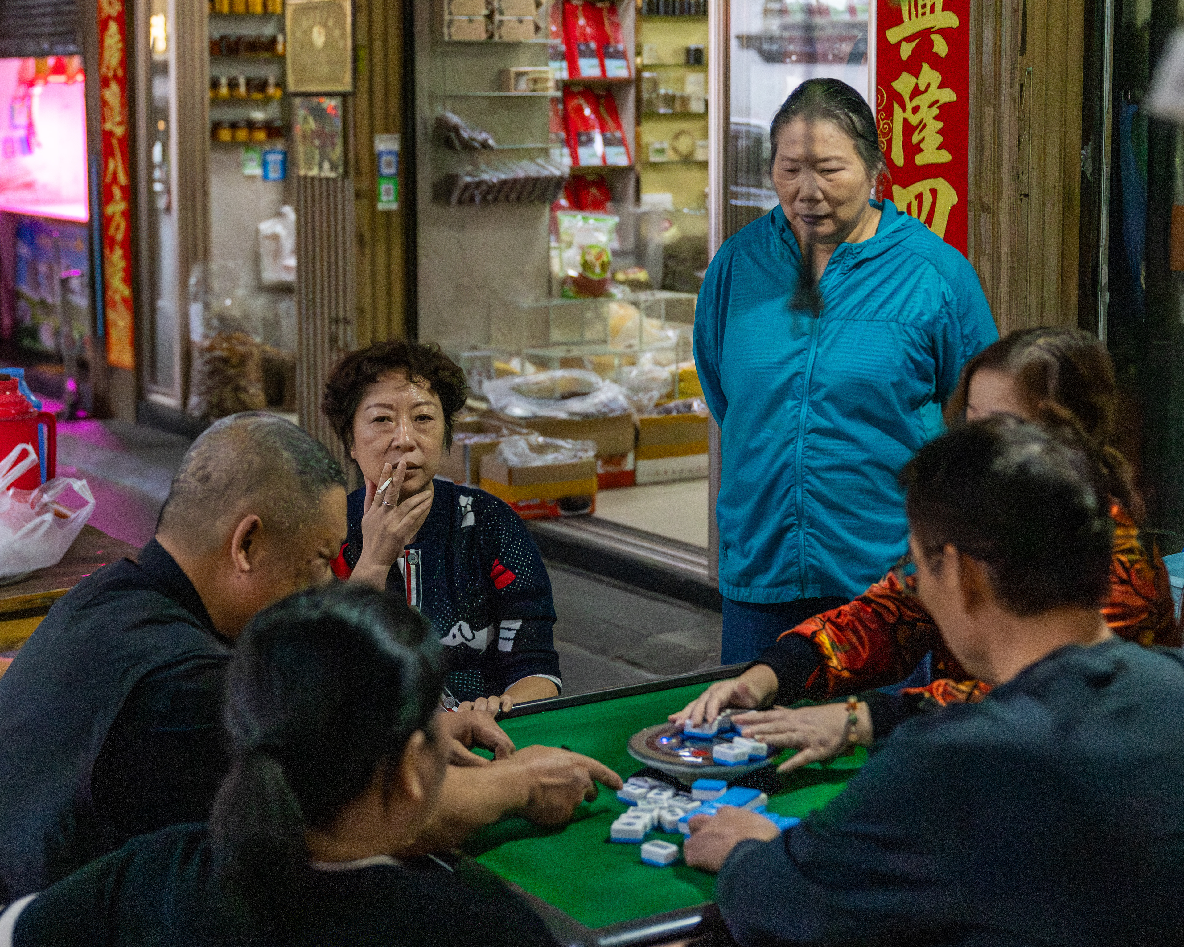 Woman smoking as she plays Majiang or mahjong (麻将), Hangzhou, China