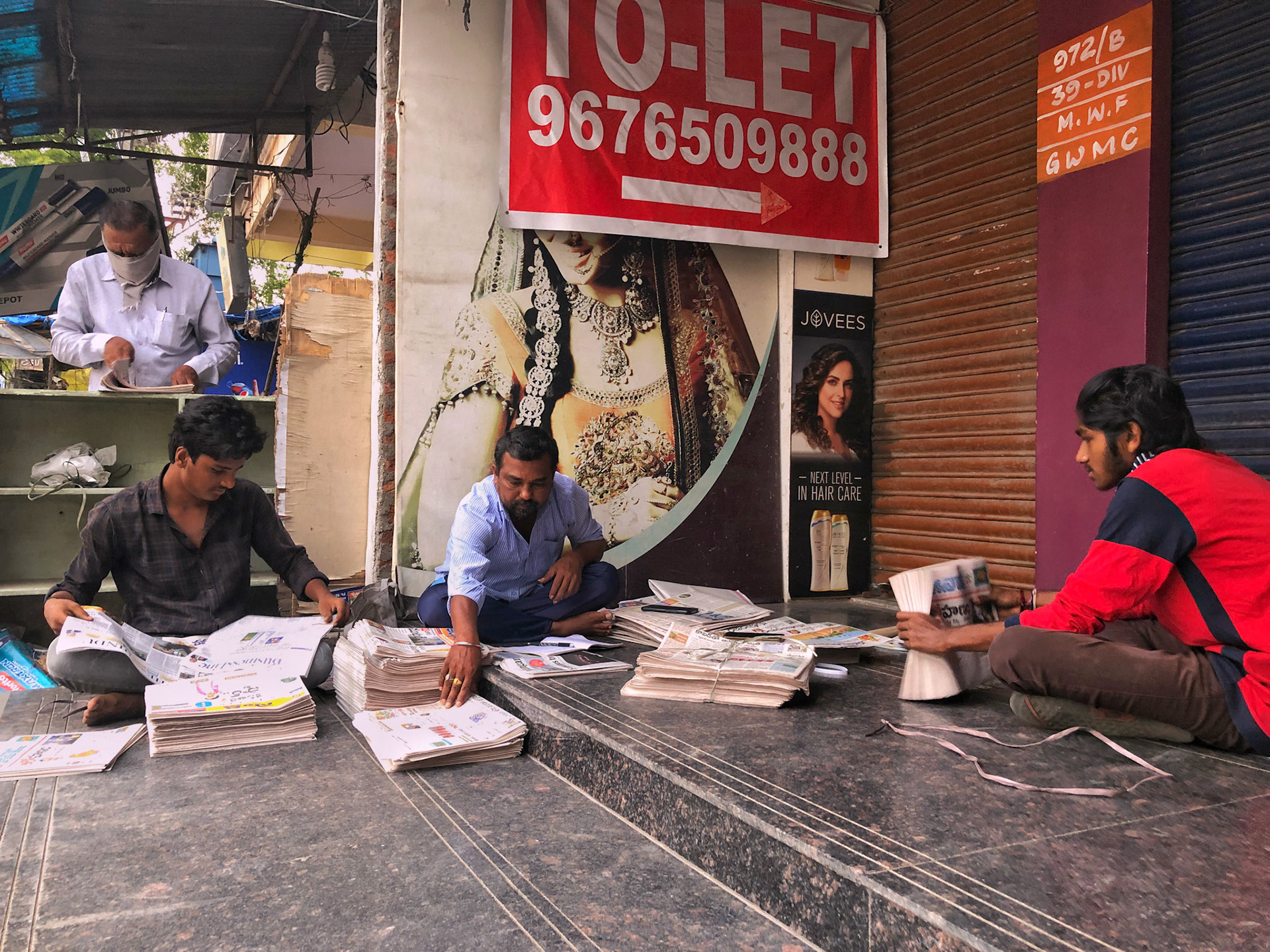 Agency owner & and his team of paperboys; arranging the newspaper sets before they leave for circulating door to door. This agency generally has 5-6 paperboys for circulating the daily newspaper but due to COVID-19, the circulation has decreased from 40-50% and this has lead to depletion of the team.