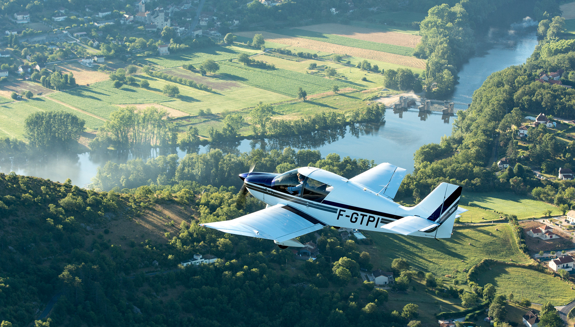 Dr400 flying over Lot river, in southern France