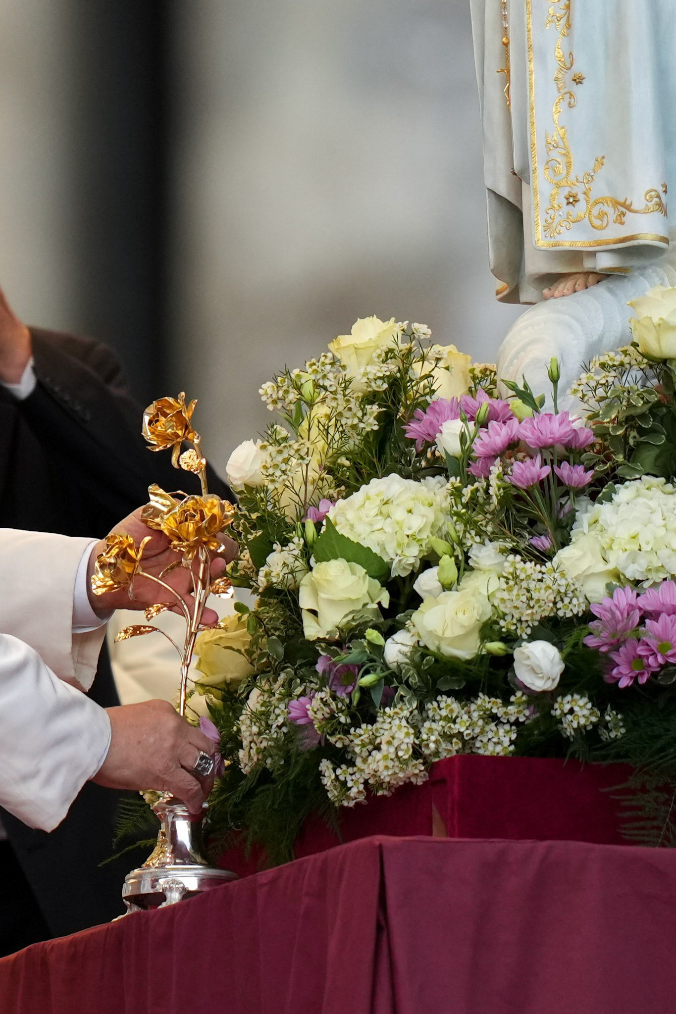 Pope Leo XIV places a gold rose in a vase at the foot of the original statue of Our Lady of Fatima in St. Peter's Square at the Vatican Oct. 11, 2025, before a prayer vigil and the recitation of the rosary for peace. The statue was brought from Portugal to Rome for the Jubilee of Marian Spirituality. (CNS photo/Lola Gomez)