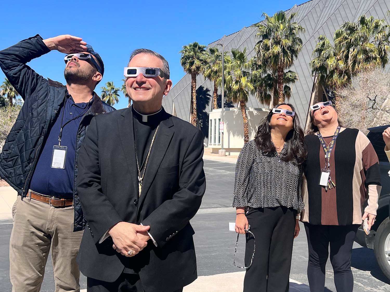 Auxiliary Bishop Gregory W. Gordon of Las Vegas and chancery staff look outside at the partial eclipse in Las Vegas April 8, 2024. A partial eclipse was visible throughout all 48 contiguous U.S. states, while a total solar eclipse was visible along a narrow track stretching from Texas to Maine. (OSV News photo/Montie Chavez, courtesy Archdiocese of Las Vegas)