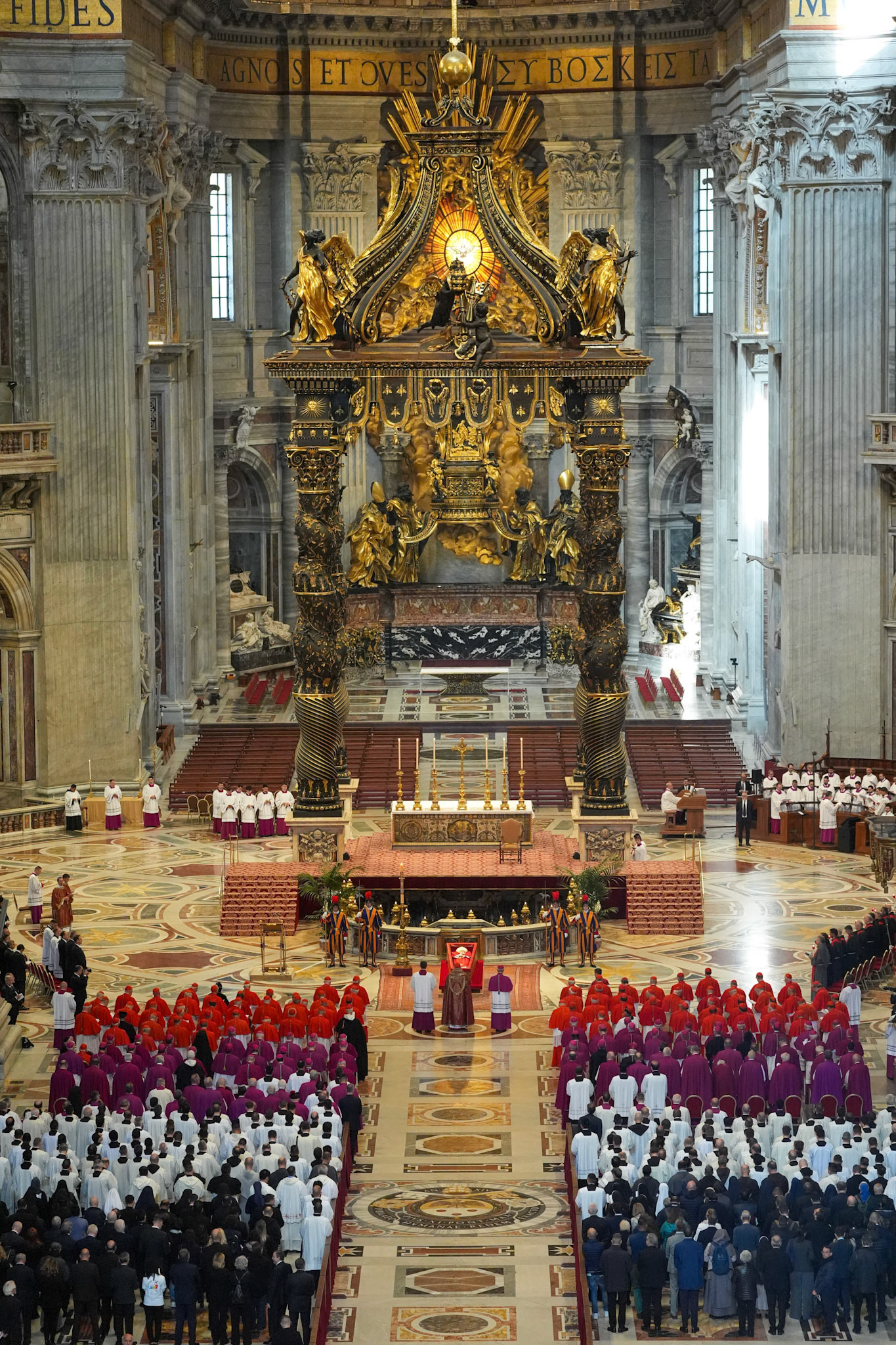 Cardinals and others stand in prayer before the body of Pope Francis in St. Peter's Basilica at the Vatican April 23, 2025. The pope, in an open casket, will lie for public viewing and prayer for three days before his funeral Mass April 26, 2025. (CNS photo/Lola Gomez)