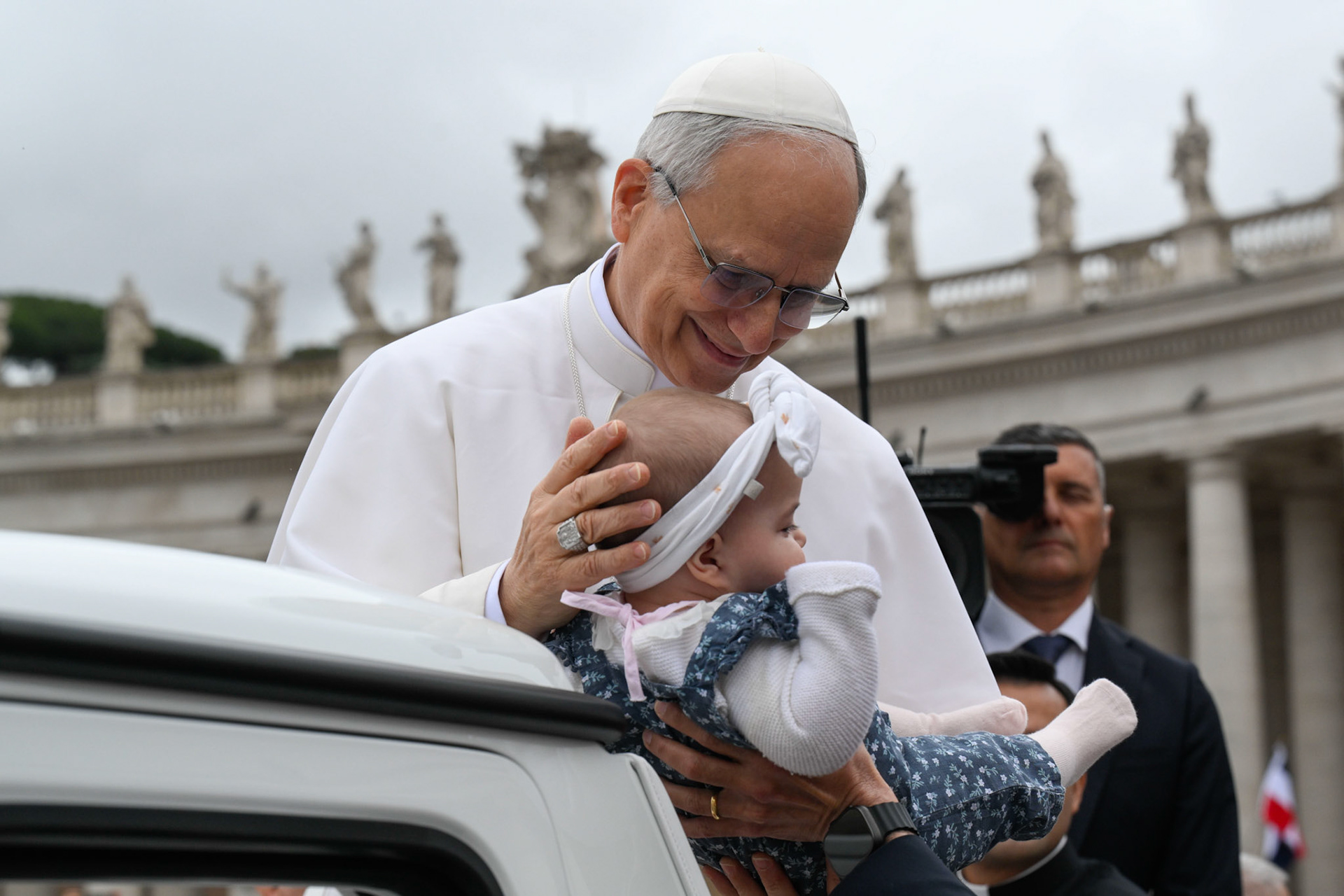 Pope Leo XIV blesses a baby as he rides in the popemobile around St. Peter's Square at the Vatican before his first weekly general audience May 21, 2025. (CNS photo/Vatican Media)