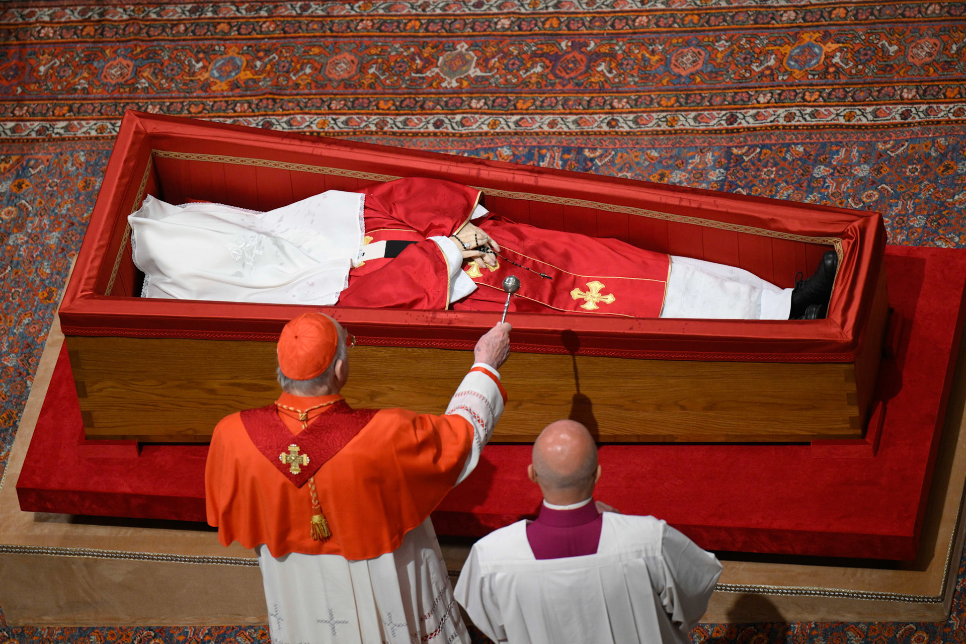 U.S. Cardinal Kevin J. Farrell, chamberlain of the Holy Roman Church, sprinkles Pope Francis' body with holy water before his casket is sealed during a prayer service in St. Peter's Basilica at the Vatican April 25, 2025. (CNS photo/Vatican Media)