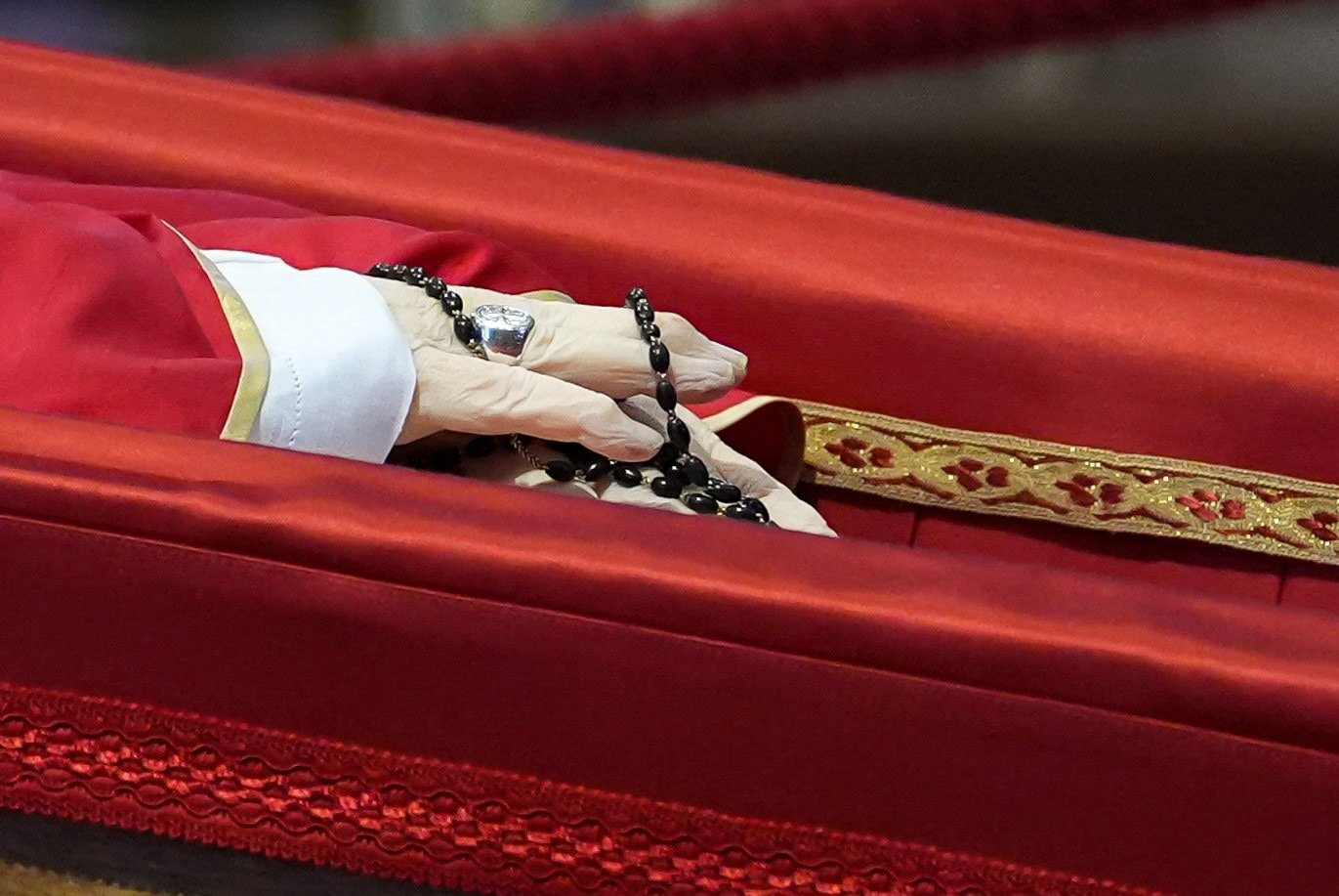 A rosary rests in the hands of Pope Francis as he lies in state in an open casket in St. Peter’s Basilica at the Vatican April 23, 2025. The pope will lie in state for three days of public viewing and prayer before his funeral Mass April 26. (CNS photo/Lola Gomez)