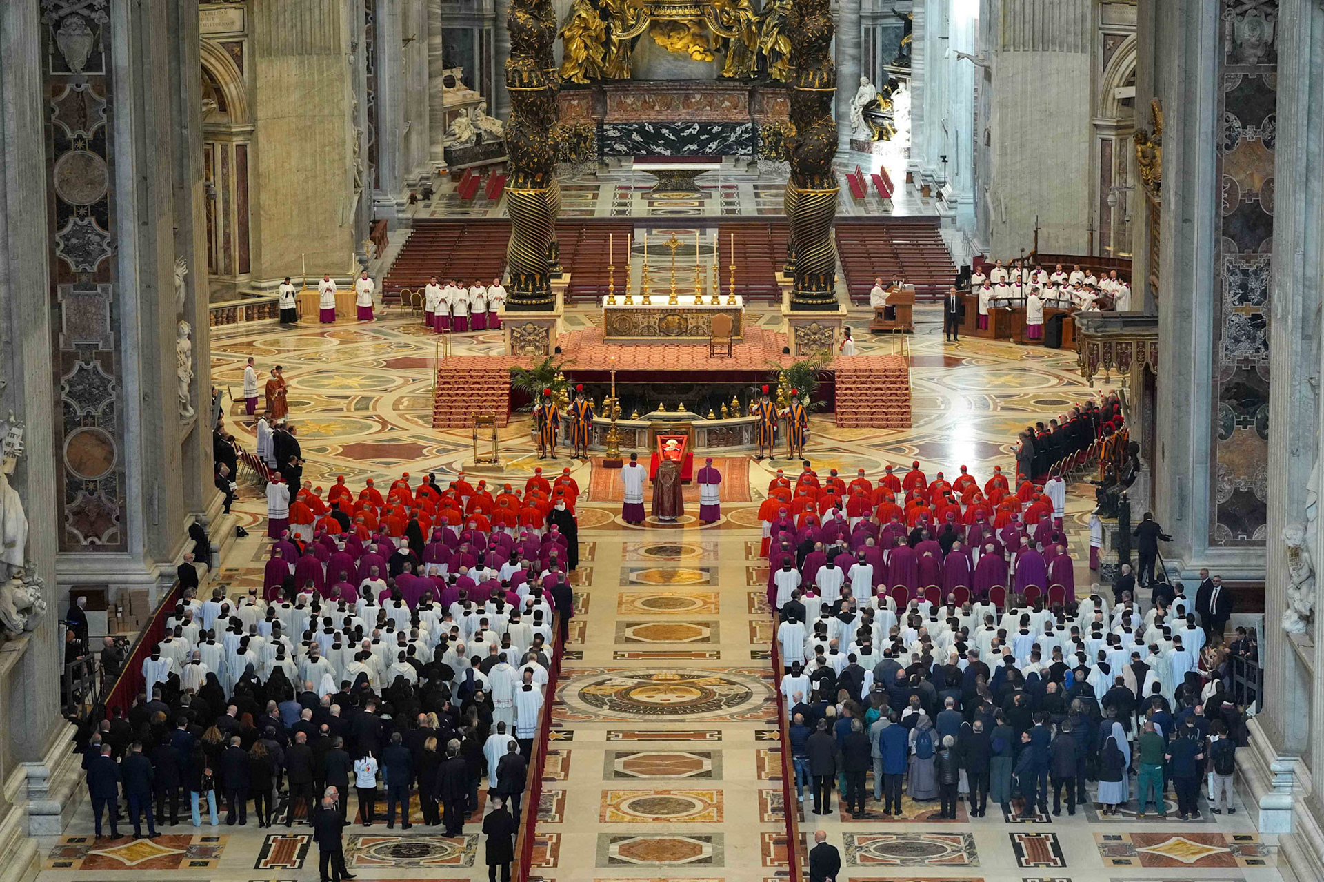 Cardinals and others stand in prayer before the body of Pope Francis in St. Peter's Basilica at the Vatican April 23, 2025. The pope, in an open casket, will lie for public viewing and prayer for three days before his funeral Mass April 26, 2025. (CNS photo/Lola Gomez)