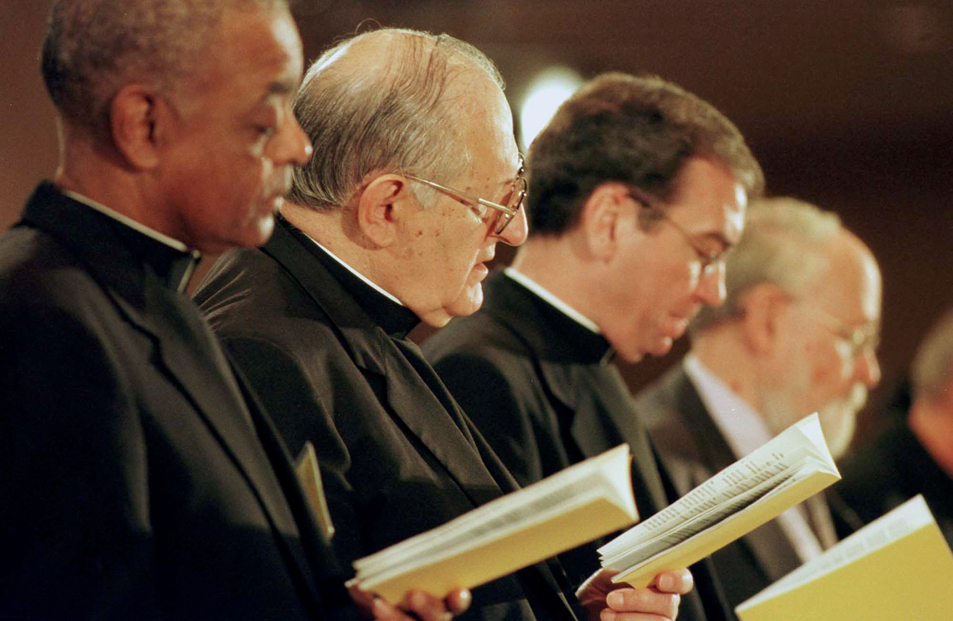 Leaders of the U.S. bishops' conference pray at the start of their annual fall meeting in Washington Nov. 13. From left is Bishop Wilton D. Gregory, vice president; Bishop Joseph Fiorenza, president; and Msgr. Dennis M. Schnurr, general secretary. (CNS photo by Bob Roller) (Nov. 13, 2000) See BISHOPS-GENERAL Nov. 13, 2000.