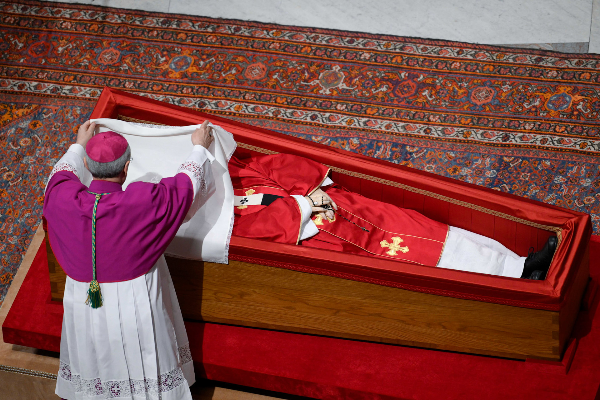 Archbishop Diego Ravelli, master of papal liturgical ceremonies, places a silk cloth over the face of the late Pope Francis before his casket is sealed during a prayer service in St. Peter's Basilica at the Vatican April 25, 2025. (CNS photo/Vatican Media)