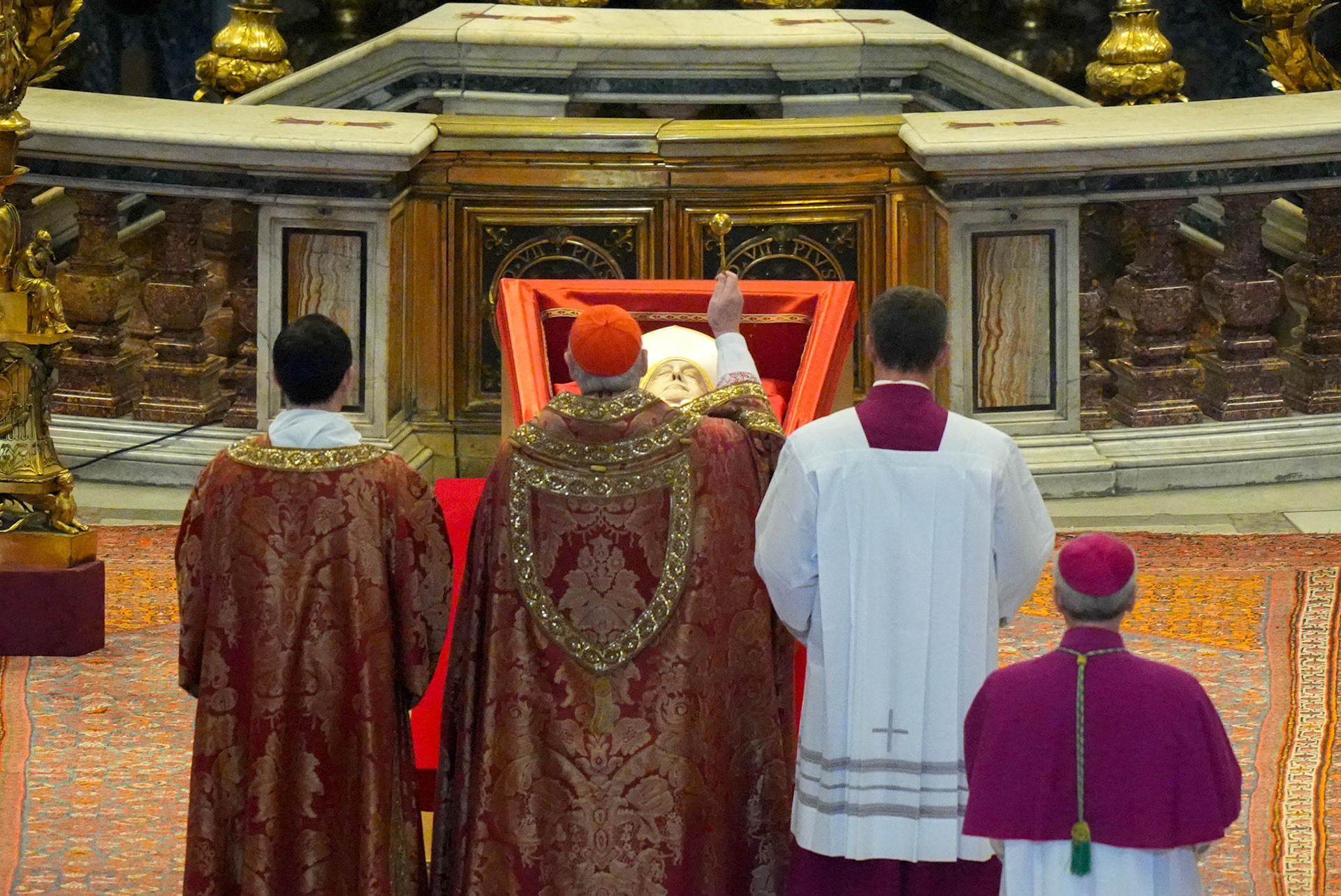 U.S. Cardinal Kevin J. Farrell, camerlengo of the Holy Roman Church, sprinkles holy water over the body of Pope Francis in St. Peter’s Basilica at the Vatican April 23, 2025. The pope, in an open casket, will lie in state for public viewing and prayer for three days ahead of his funeral Mass April 26. (CNS photo/Lola Gomez)