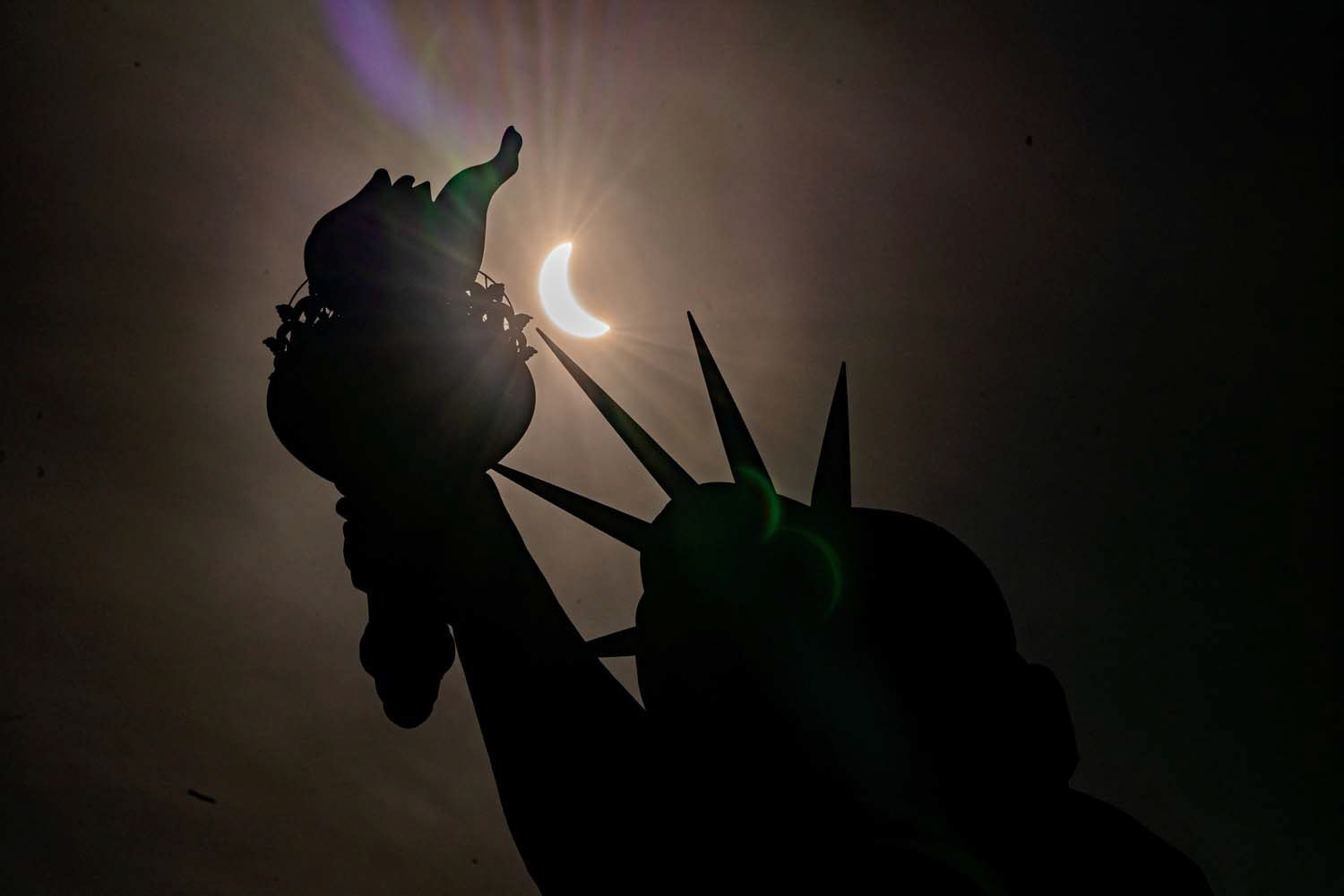 The Statue of Liberty is seen during a partial solar eclipse at Liberty Island in New York City April 8, 2024. A partial eclipse was visible throughout all 48 contiguous U.S. states, while a total solar eclipse was visible along a narrow track stretching from Texas to Maine. (OSV News photo/David Dee Delgado, Reuters)