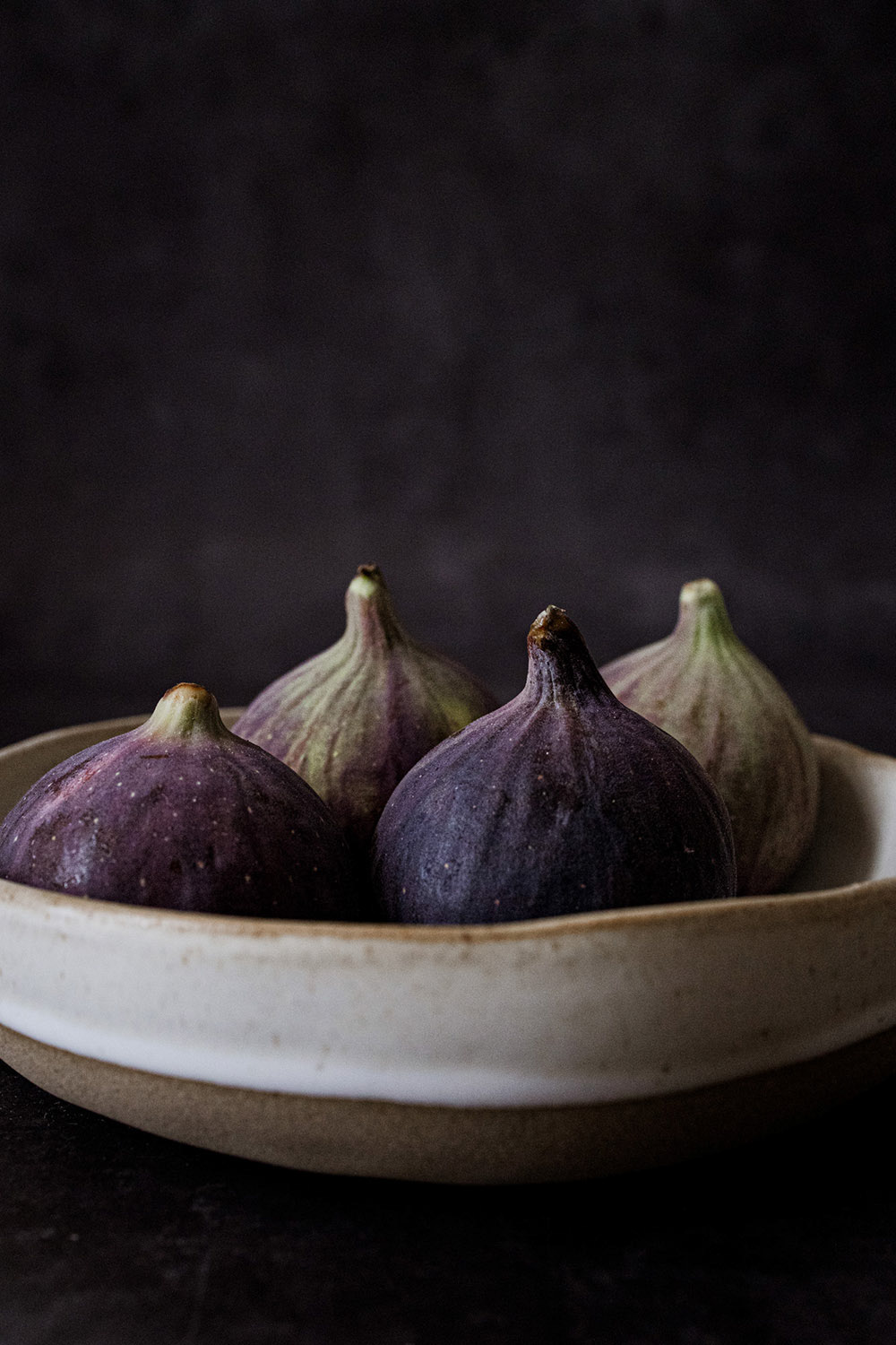 Close up front shot of figs huddled in a bowl.