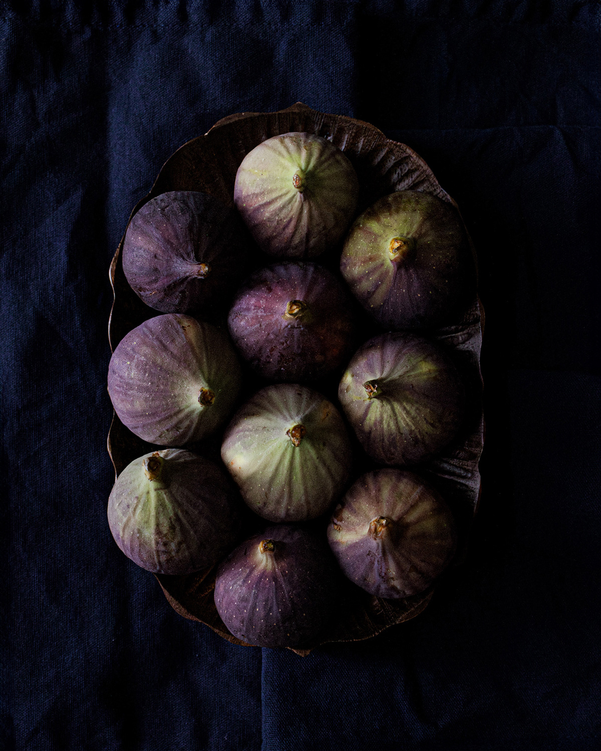 top view of figs in a wooden plate.