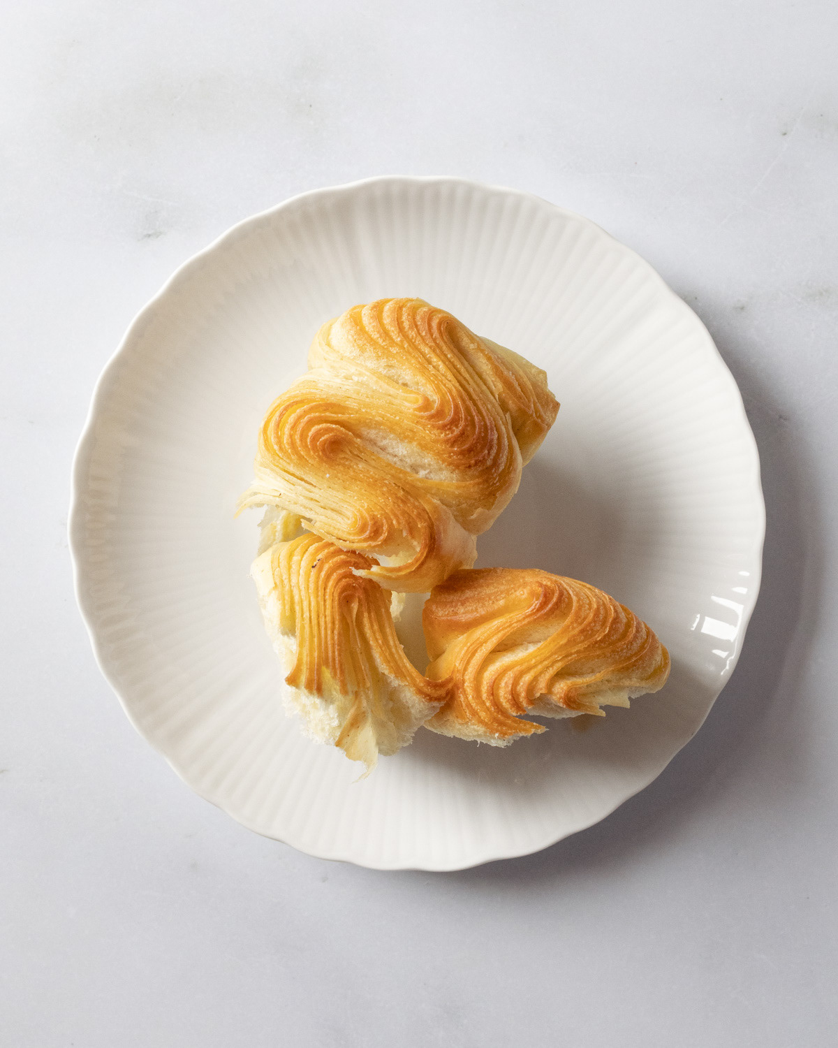 Top view of pieces of brioche on a white plate.
