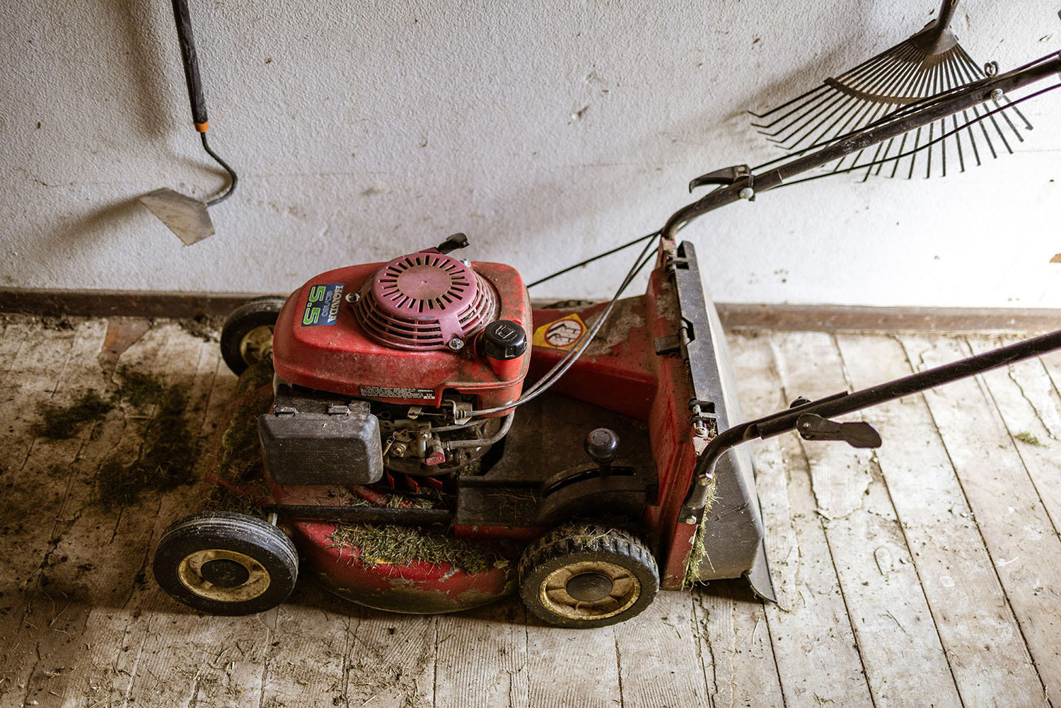 A well used lawn mower in a garden shed
