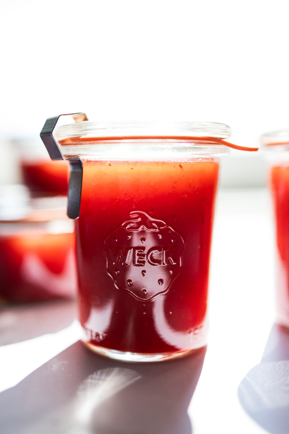 Front view of freshly home made strawberry jam backlit by sunshine.