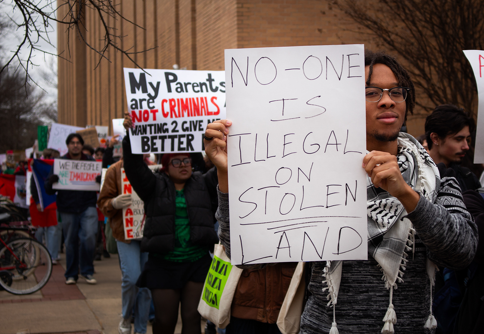 As protesters against the deportation of immigrants marched around the University of North Texas campus on Wednesday, Feb. 12, handwritten signs and Mexican flags are held high by many participants. Photo/ Natalie VanDerWal