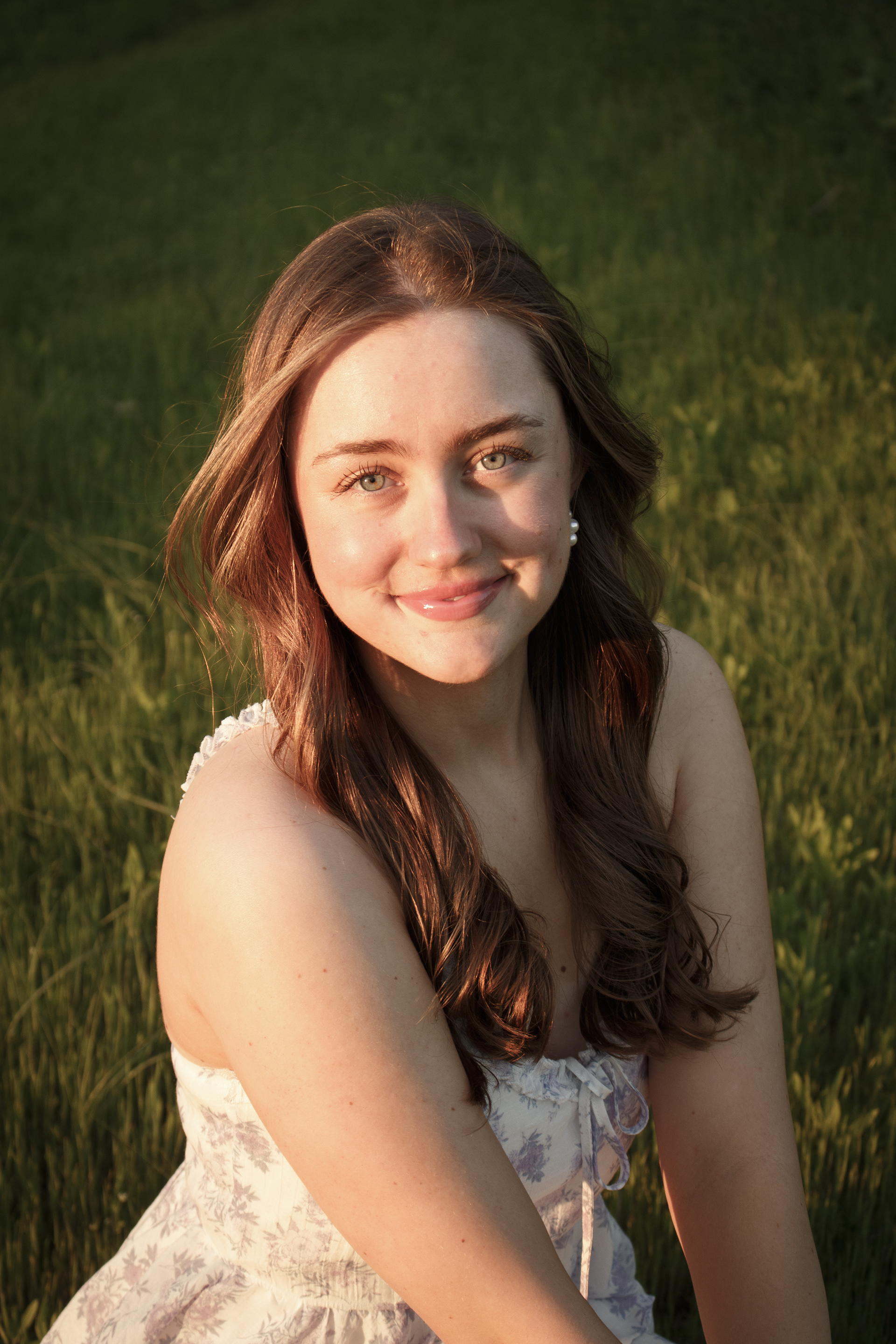 Jade Winn poses in a field of grass for her senior portraits at Arbor Hills Nature Preserve in Plano, Texas on April 13, 2024. Winn is now a graduate from the University of North Texas with a Bachelor of Science in Integrative Studies with a focus on Business, Communications and Psychology. Photo/ Natalie VanDerWal