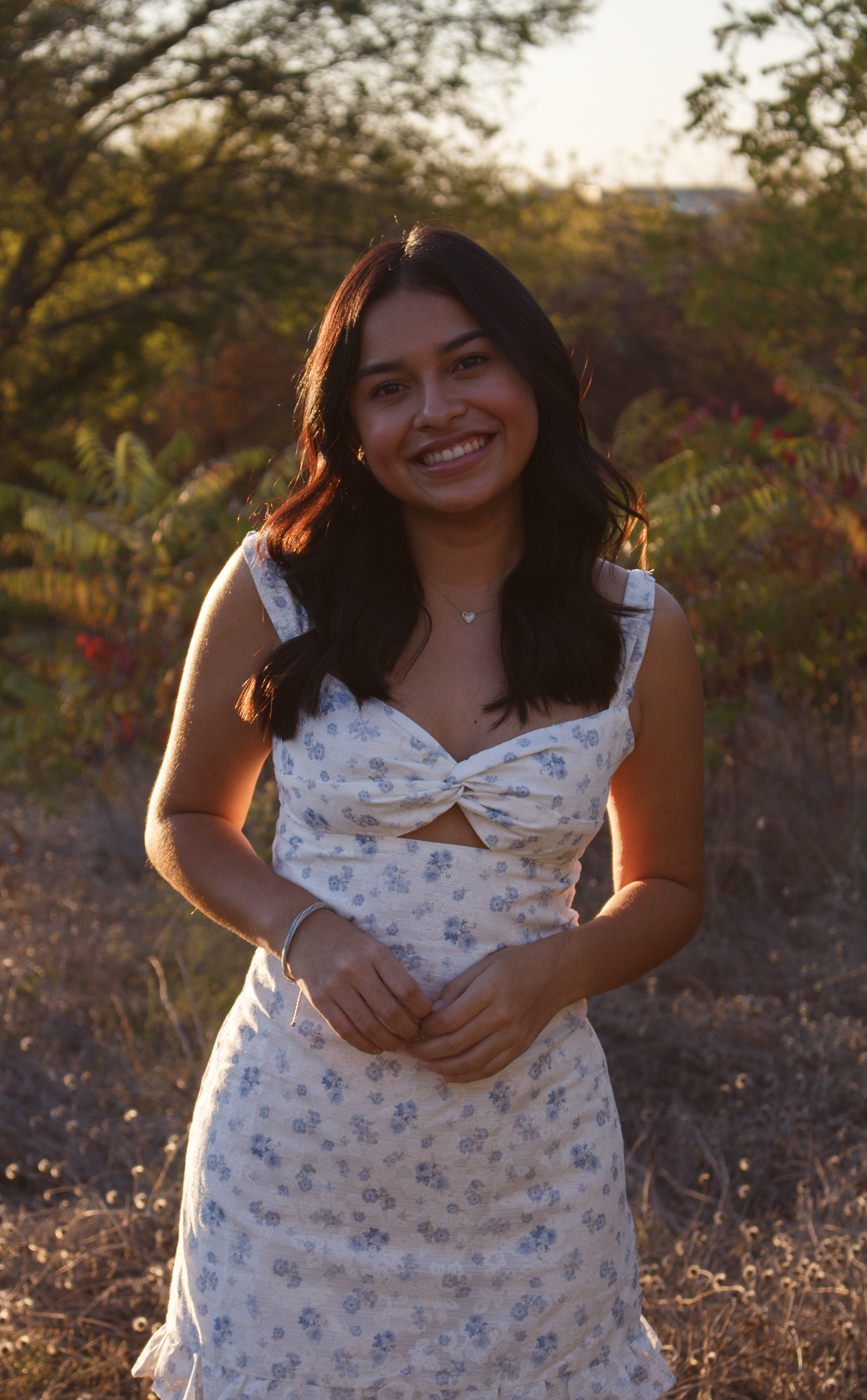 Gabriela Alaniz fidgets with her fingers in front of her as the sun casts a glow on her hair during her portrait session at Arbor Hills Nature Preserve on Nov. 10, 2024. Photo/ Natalie VanDerWal