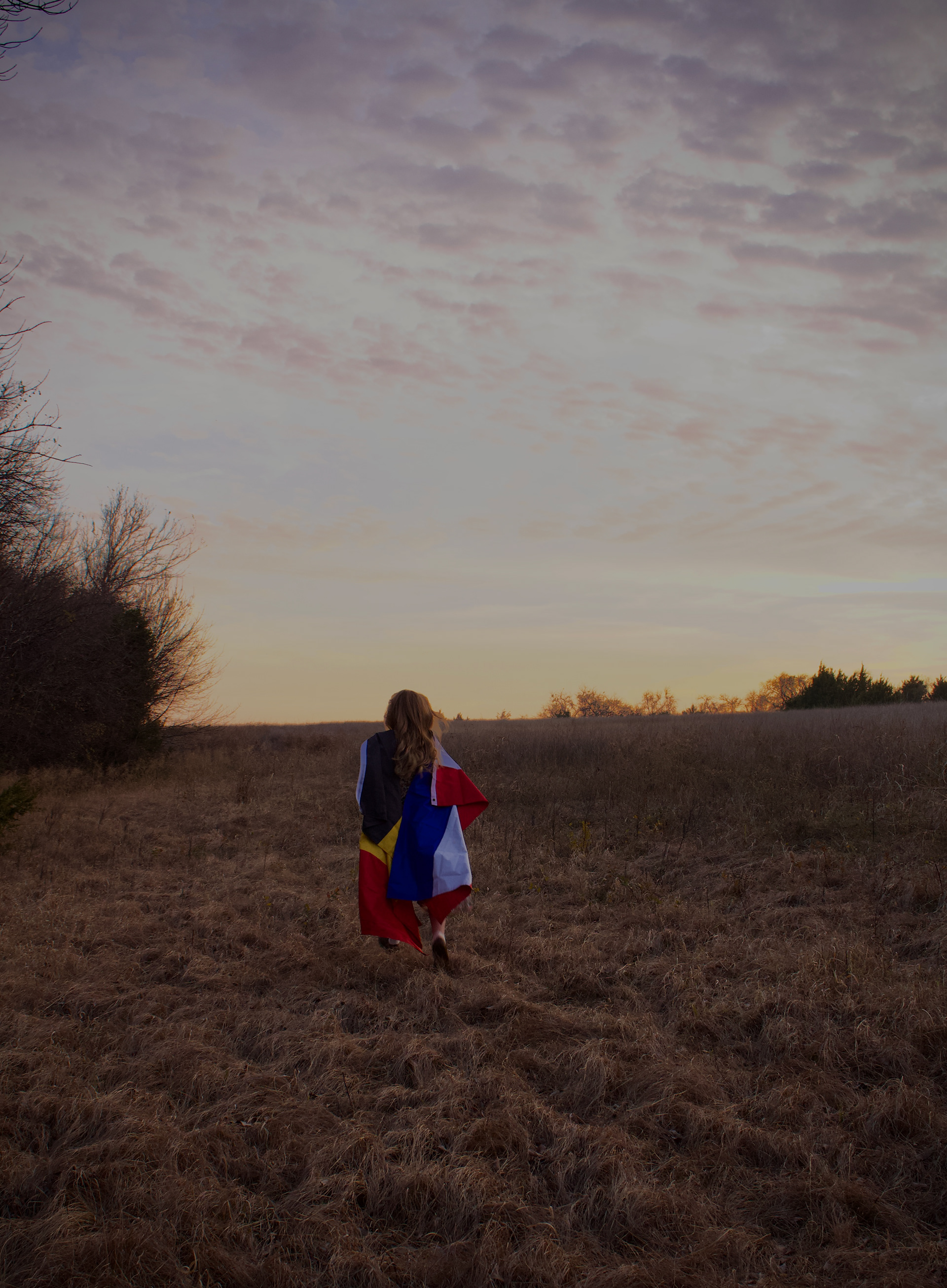 MCKINNEY, TEXAS Dec. 3, 2025 Neve Richmonds holds the Belgian and Dutch flags over her shoulders as she frolics through a field at a park in McKinney, Texas. Photo/ Natalie VanDerWal