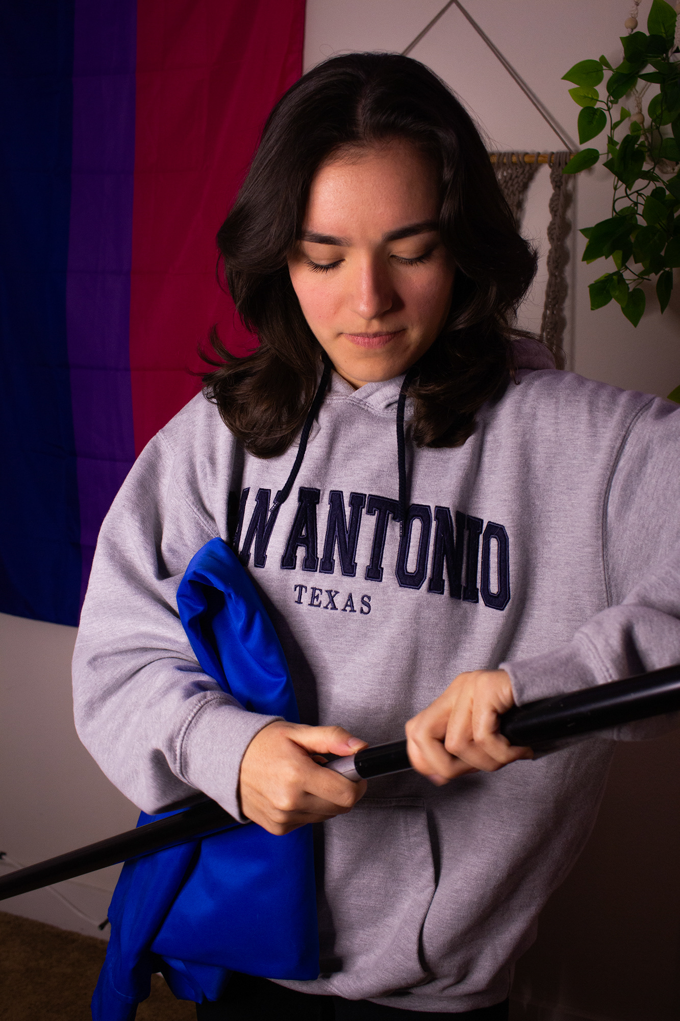 Jaylen Jackson prepares for an audition on Wednesday, Feb. 19, 2025 and is putting the frame together that holds up her blue backdrop. This part of the audition process is the most frustrating for Jackson; her room is too small, her equipment is too big and its very hard to do alone. Photo/ Natalie VanDerWal