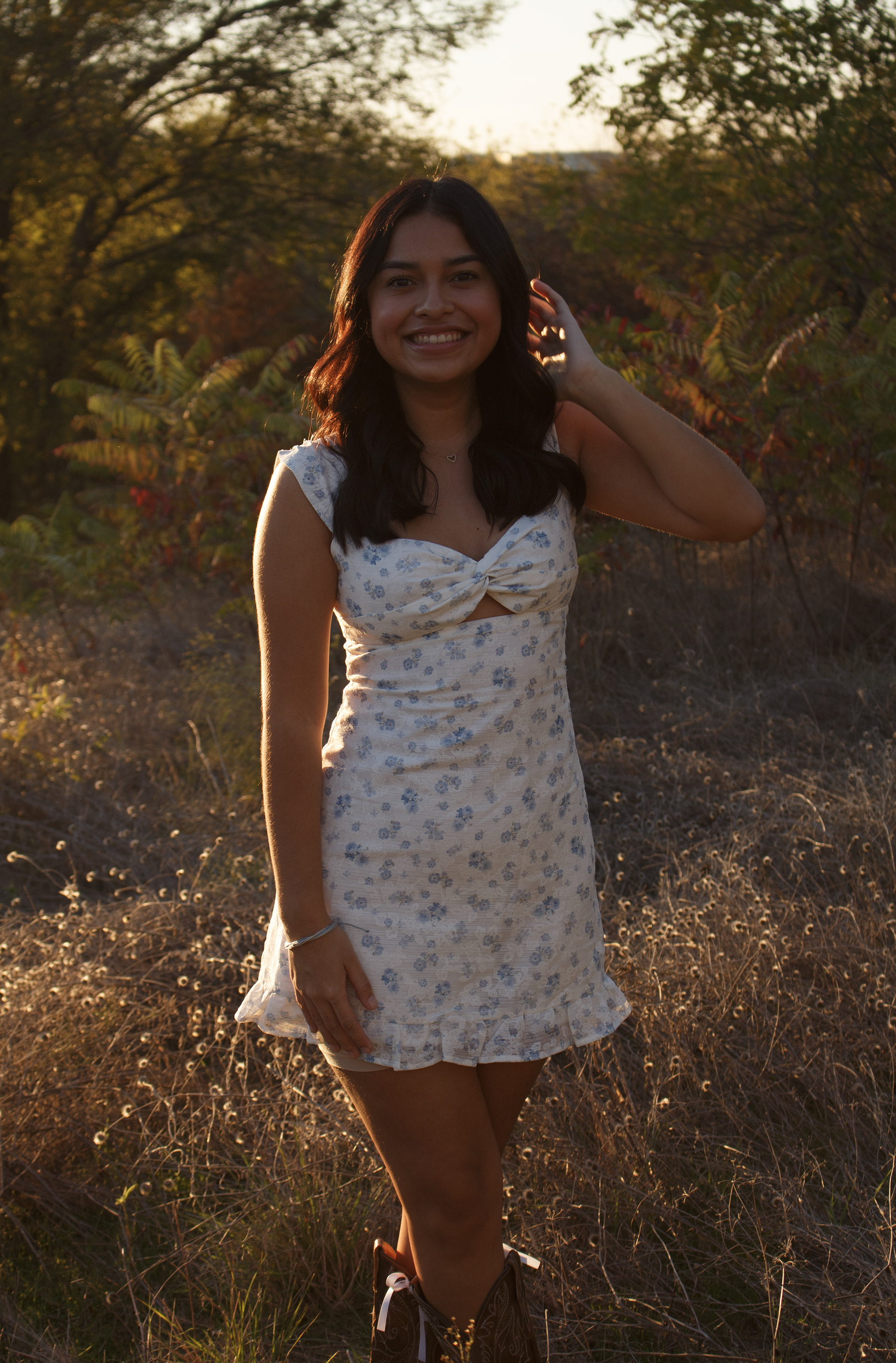High school senior Gabriela Alaniz fixes her hair as she poses in her cowgirl boots at Arbor Hills Nature Preserve on Nov. 10, 2024. Photo/ Natalie VanDerWal