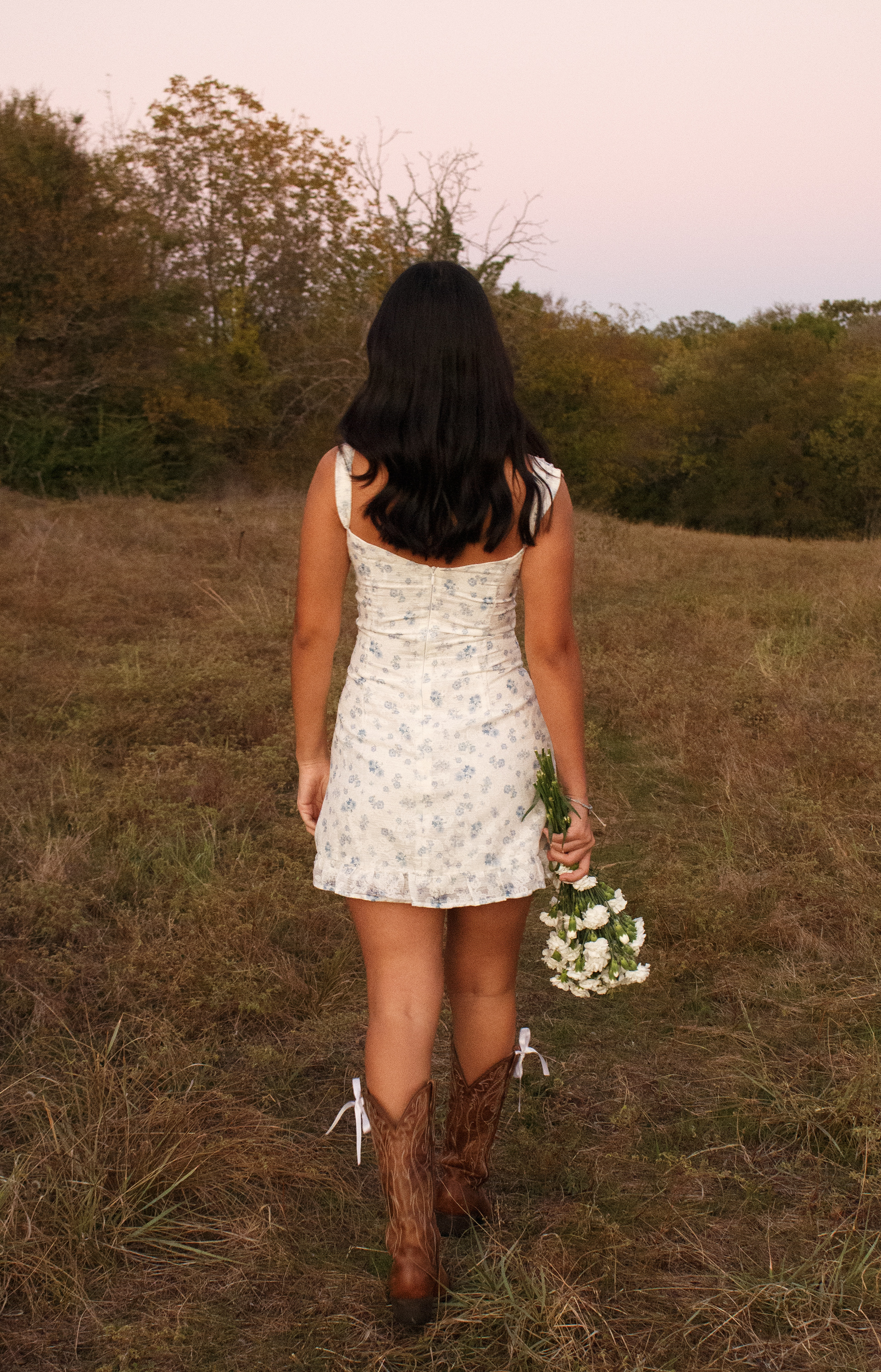 Gabriela Alaniz strolls through the dried grass at the Arbor Hills Nature Preserve on Nov. 10, 2024, holding her bouquet of carnations down by her side. Photo/ Natalie VanDerWal