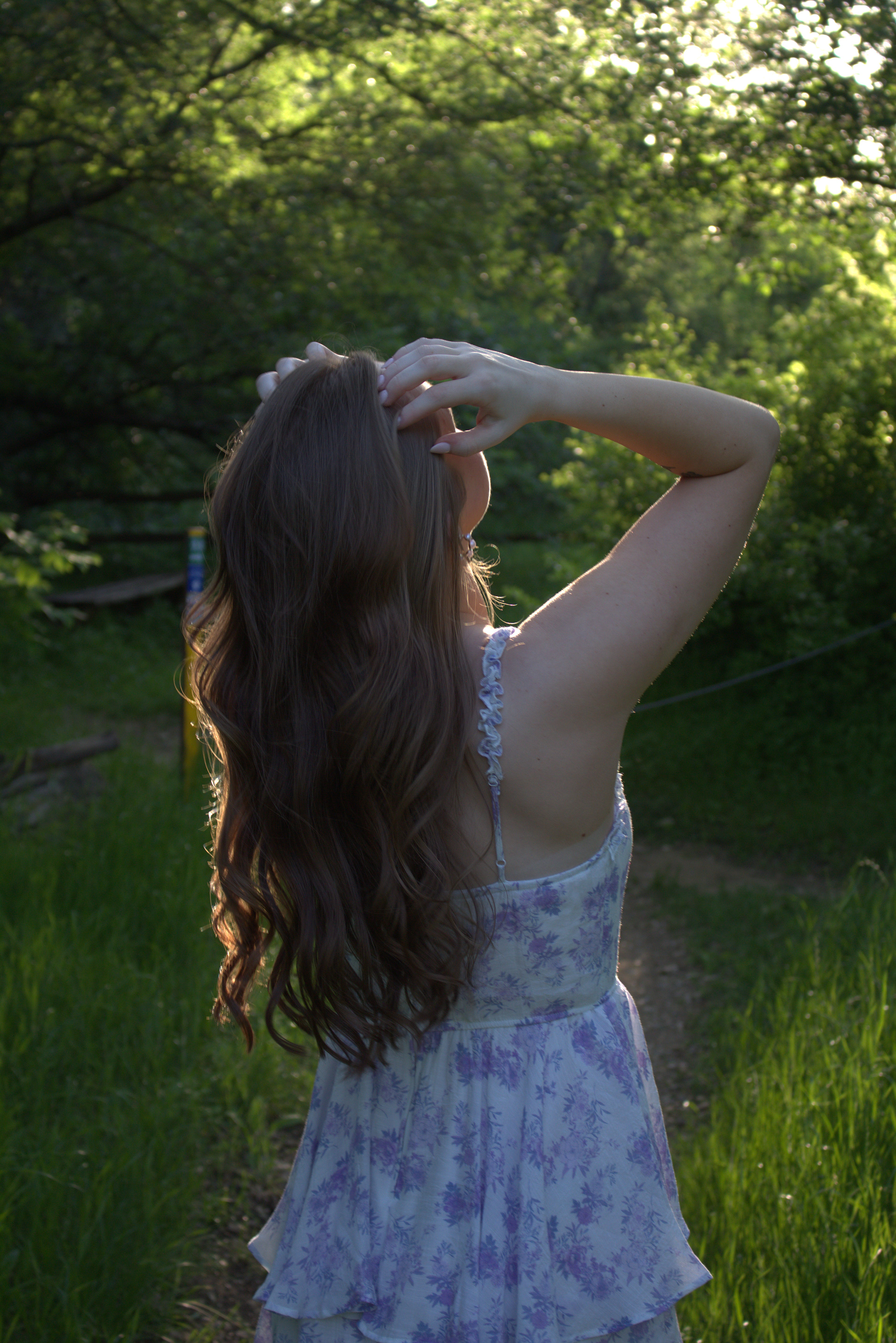 University of North Texas graduate Jade Winn runs her fingers through her hair in a candid shot during her senior portrait session at Arbor Hills Nature Preserve on April 13, 2024. Photo/ Natalie VanDerWal