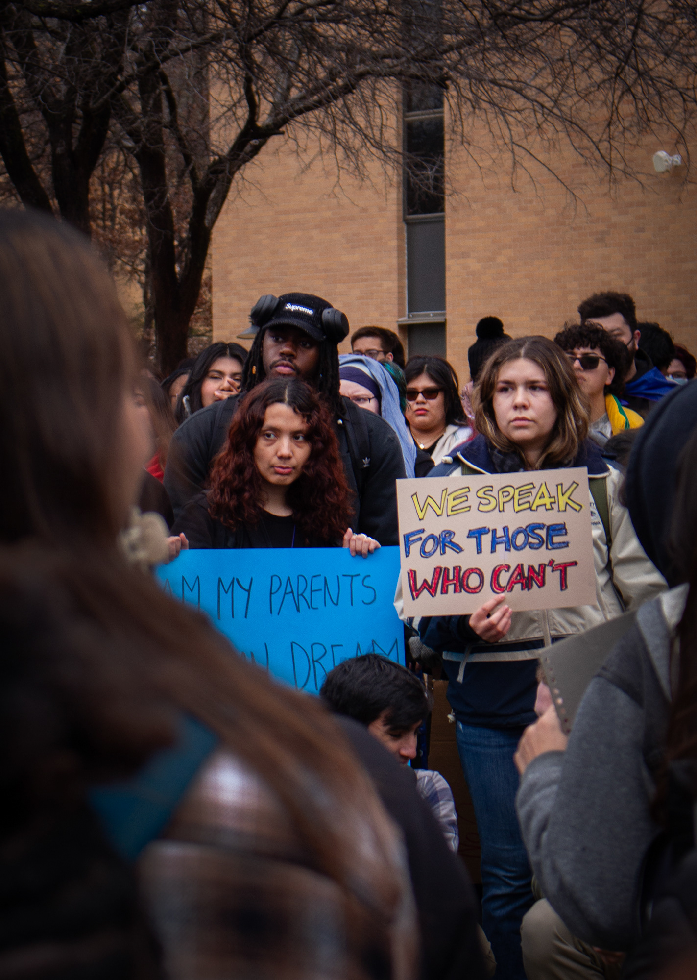 Gathered around people speaking in the Library Mall on the University of North Texas campus Wednesday, Feb. 12, protesters with signs listen with grim looks on their faces. ICE agents were rumored to have been on campus in the days prior, which fueled emotions at this protest. Photo/ Natalie VanDerWal