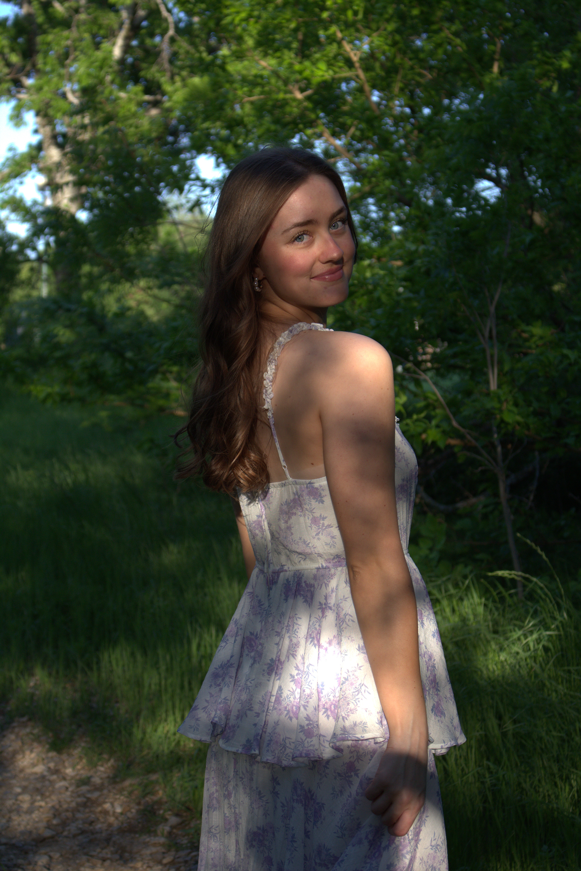 Jade Winn smiles over her shoulder as the sun casts a patterned shadow on her through the trees at Arbor Hills Nature Preserve in Plano, Texas on April 13, 2024. Photo/ Natalie VanDerWal
