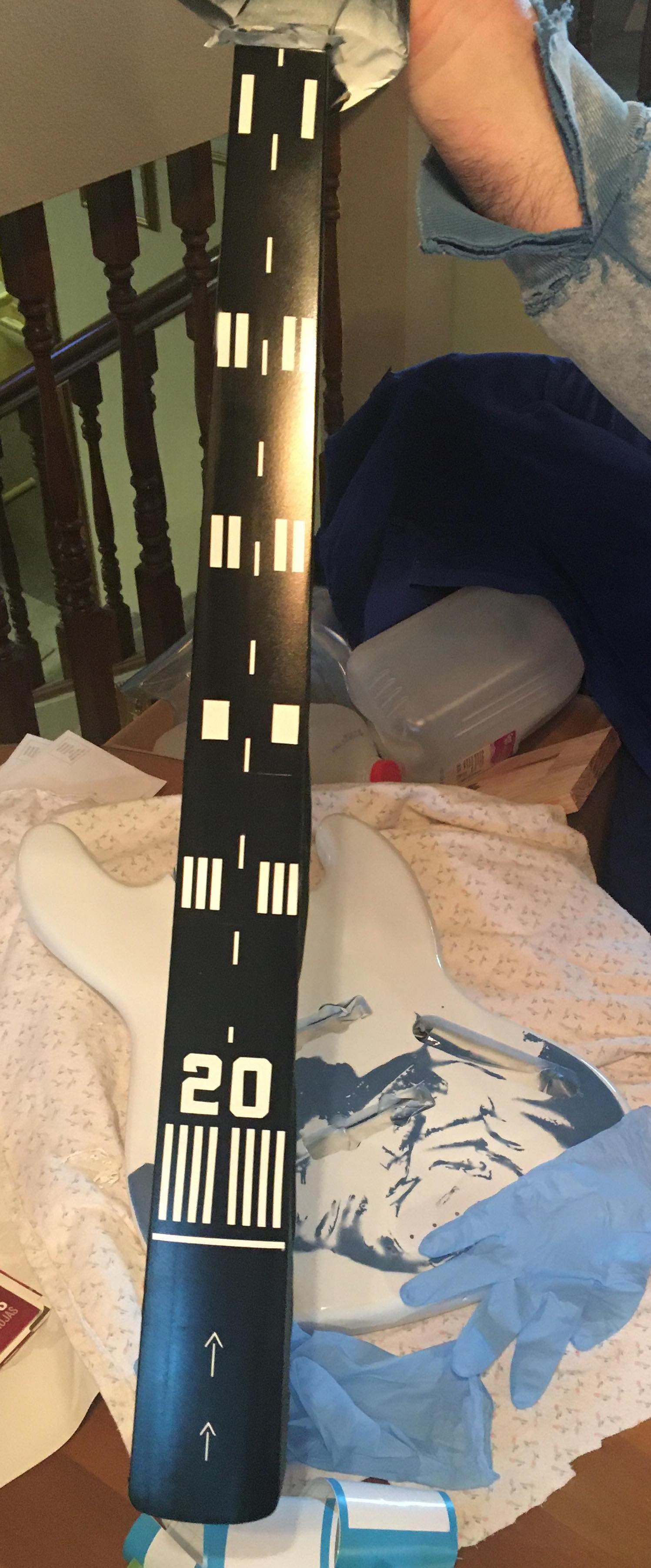 Photo of a bass guitar neck with airport runway markings