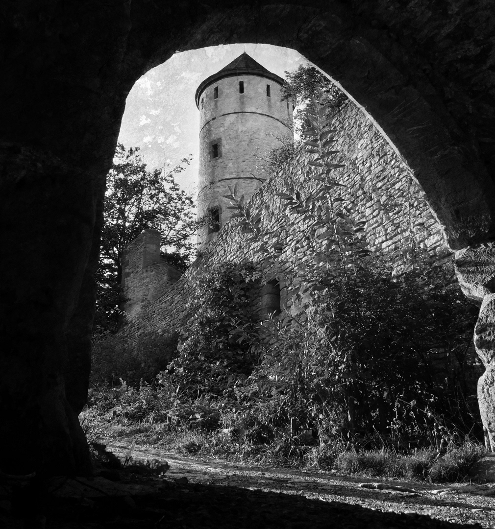 Black and white photograph of Burg Plesse seen through and arch in Gottingen, Germany