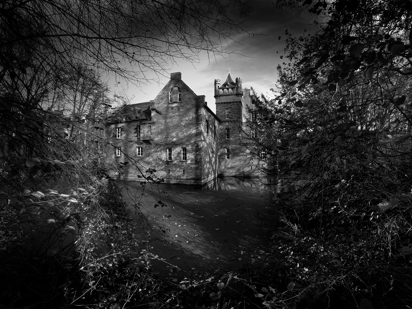 A black and white photograph of the moat surrounded castle of Werdringen near Hagen in Germany