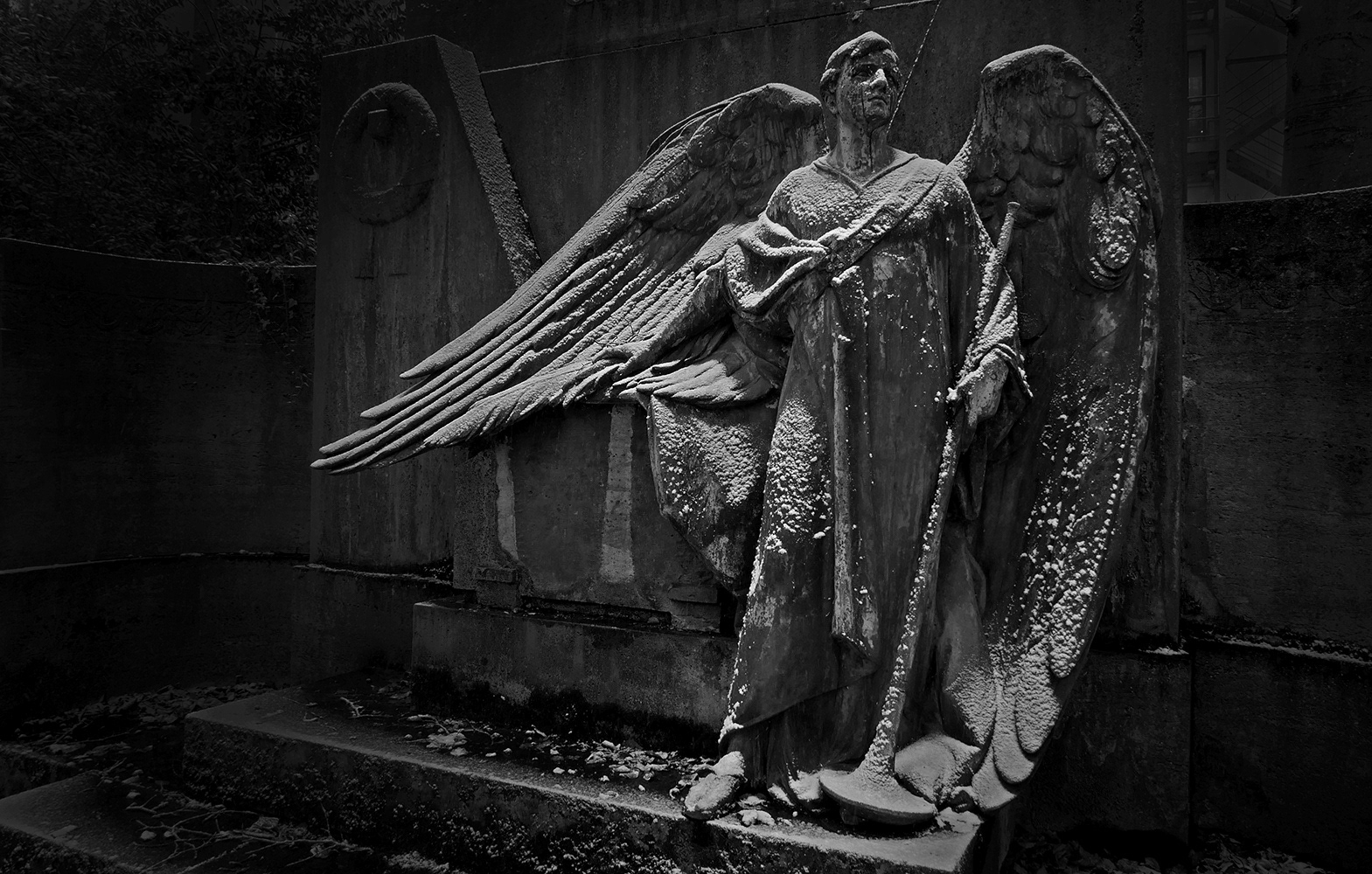 Black and white photograph of a cemetry angel with buisine in the Snow at Kortumpark Bochum Germany