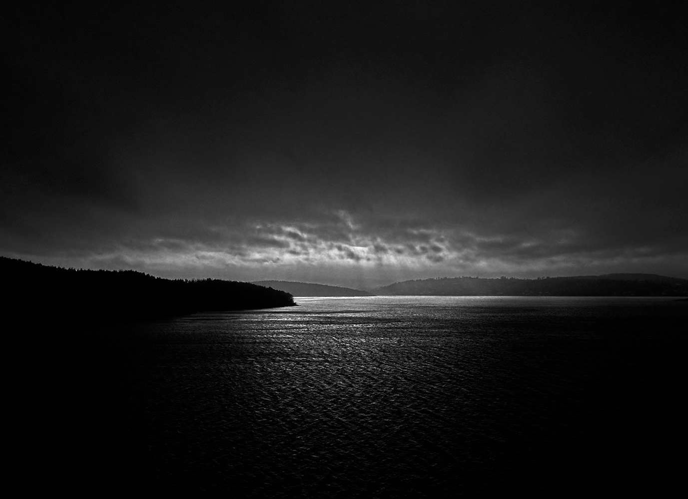 Black and white photograph of darkness falling over the fjord in Norway