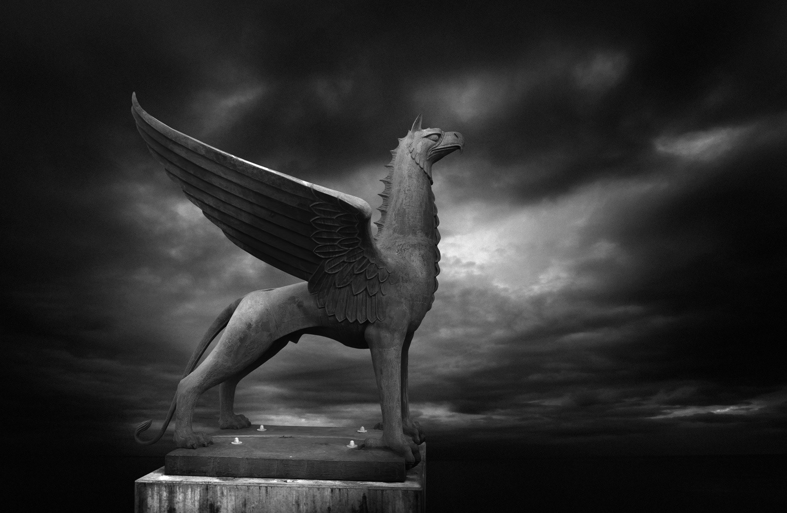 Black and white photograph of a Griffin against a dark stormy sky
