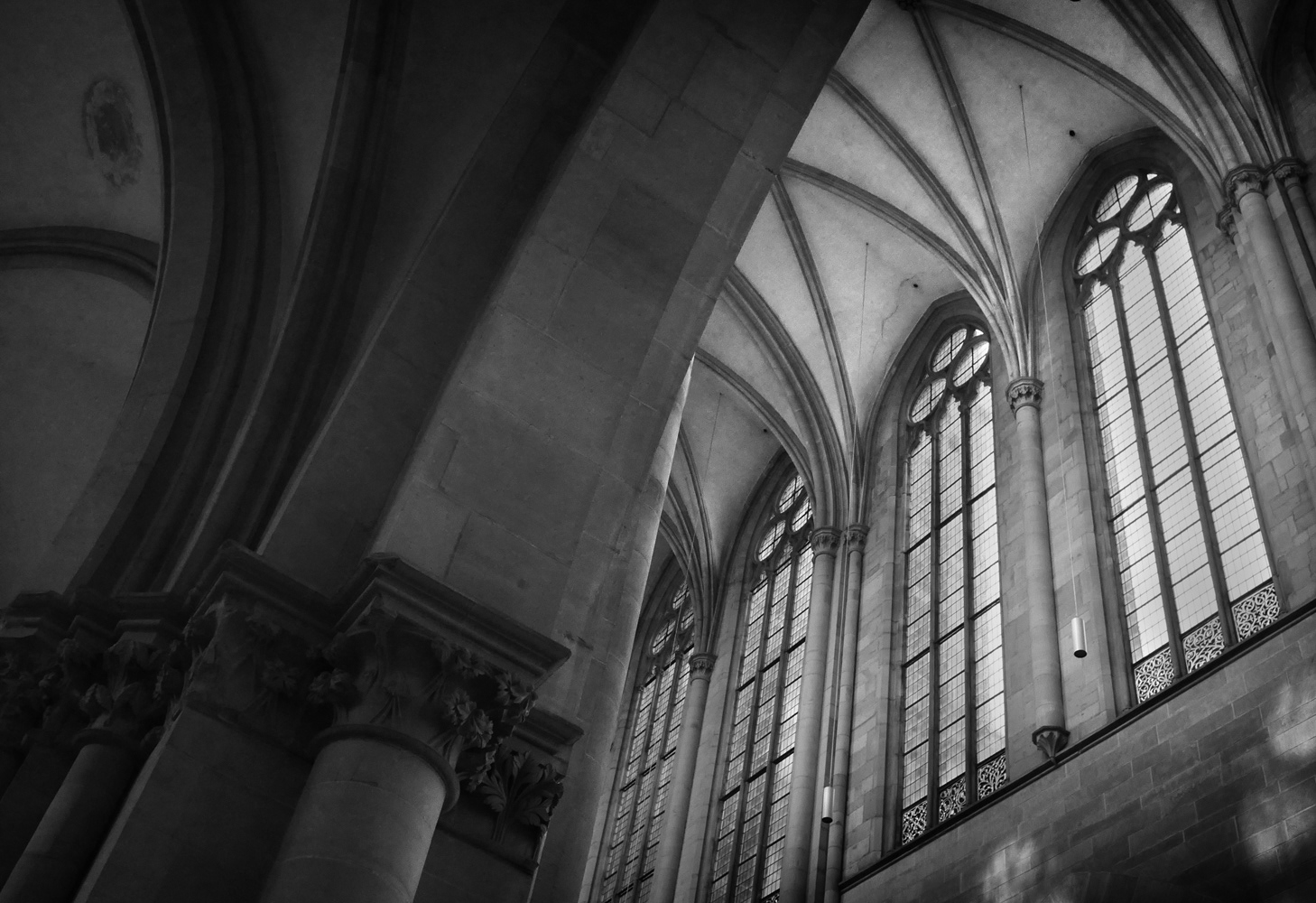 Black and whit photograph of the interior of Magdeburg Cathedral showing towering windows and vaulted ceilings.