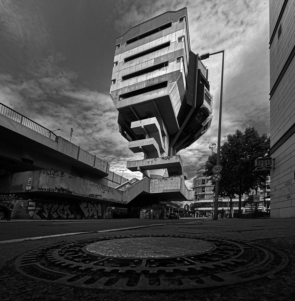 Black and white photograph of a manhole and Bierpinsel - Steglitz - Berlin - Germany