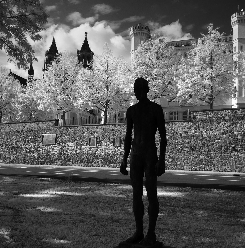 Black and white infrared photograph of a man standing against classical buildings. A rare 1/1 NFT and print. 