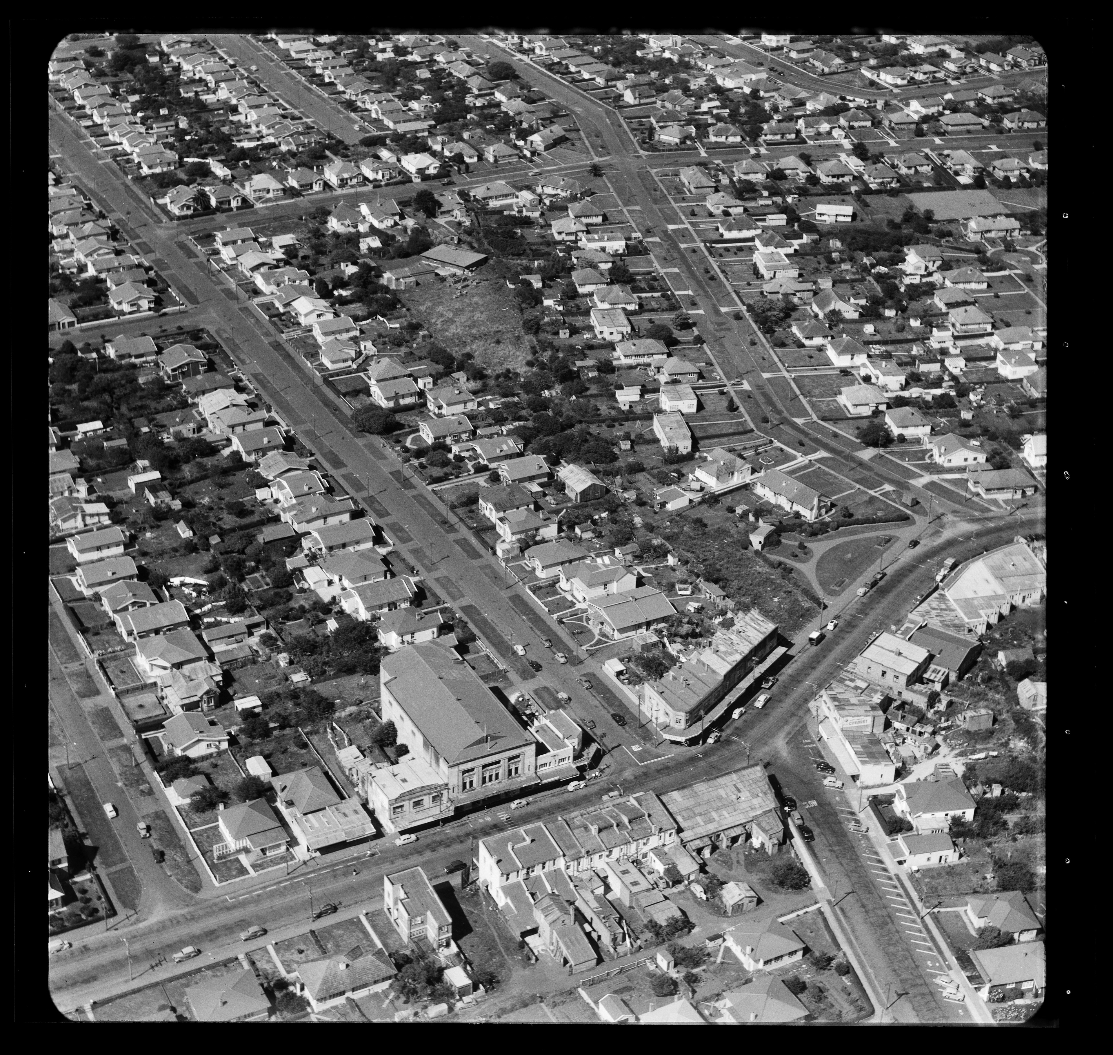 Photograph from the Whites Aviation collection, circa 1957, showing the Sandringham shops with the Mayfair Theatre in the foreground. The intersection of Sandringham and Kitchener Roads can be seen in the bottom right third. Alexander Turnbull Library WA-43969.