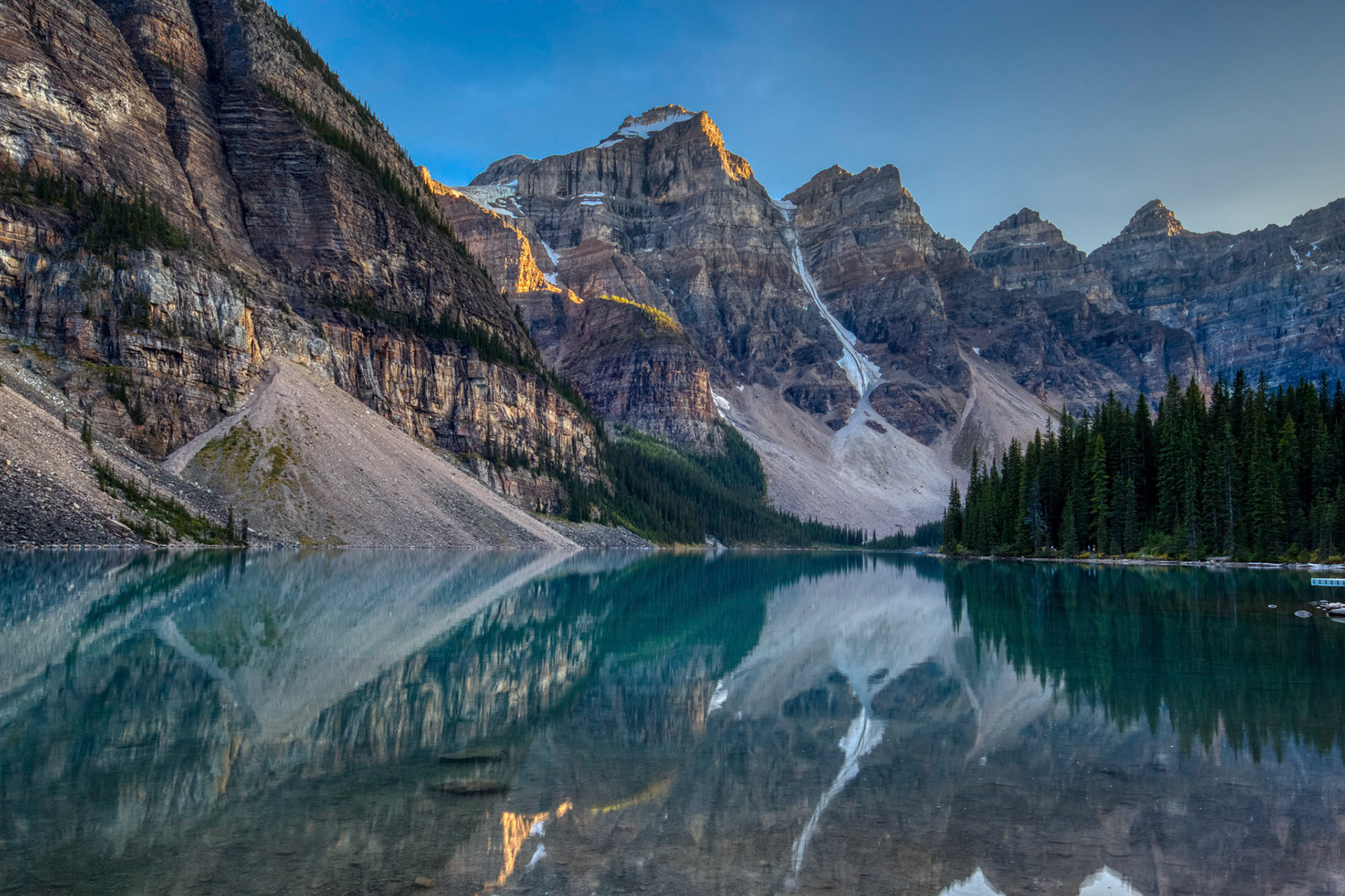 Breathtaking view of Moraine Lake at sunset situated in the Valley of the Ten Peaks with mirror-like reflections on the water, Banff National Park, Alberta, Canada