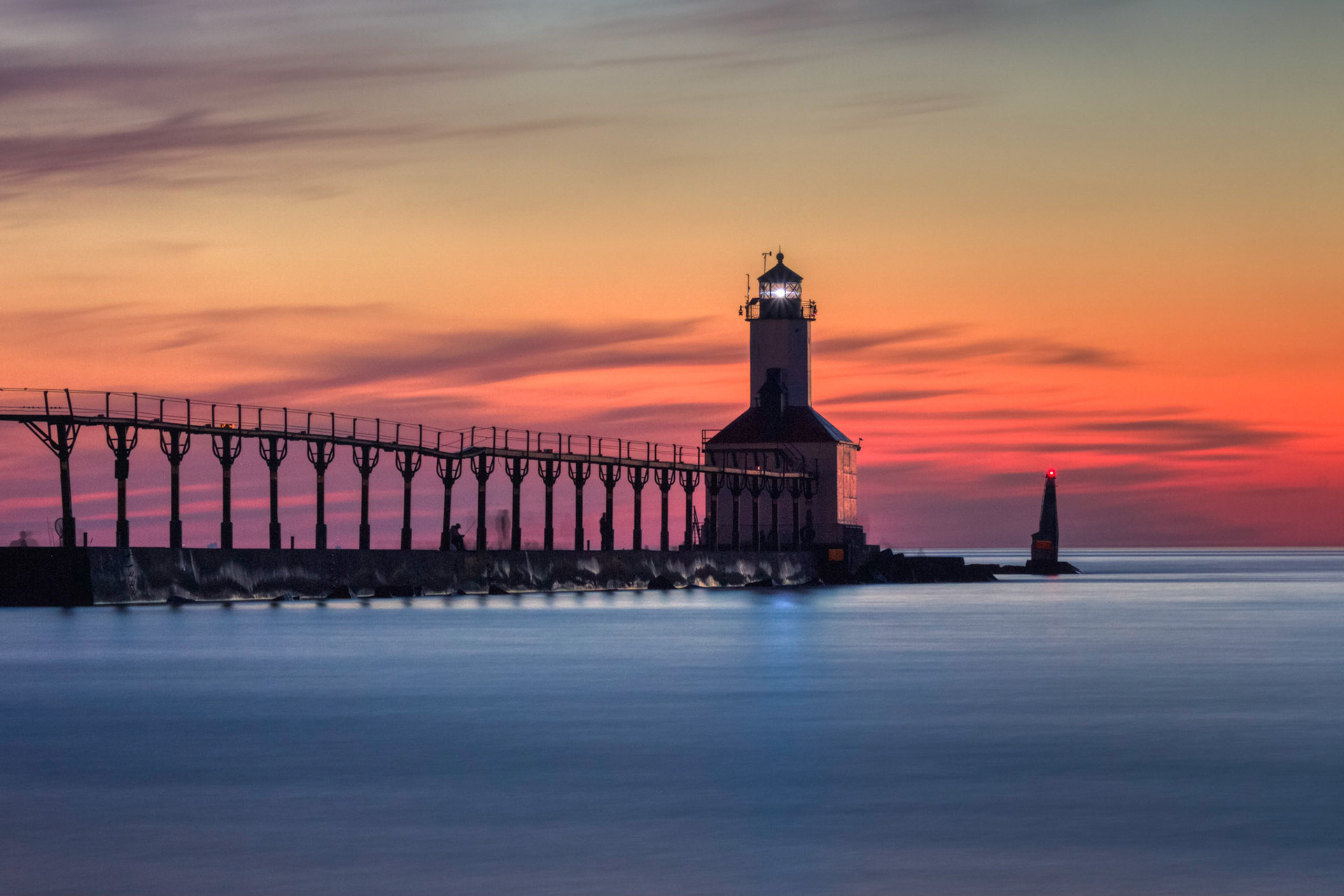 Long exposure shot of Michigan City East Pierhead Lighthouse after sunset with colorful sky and dramatic clouds, Washington Park Beach, Michigan City, Indiana