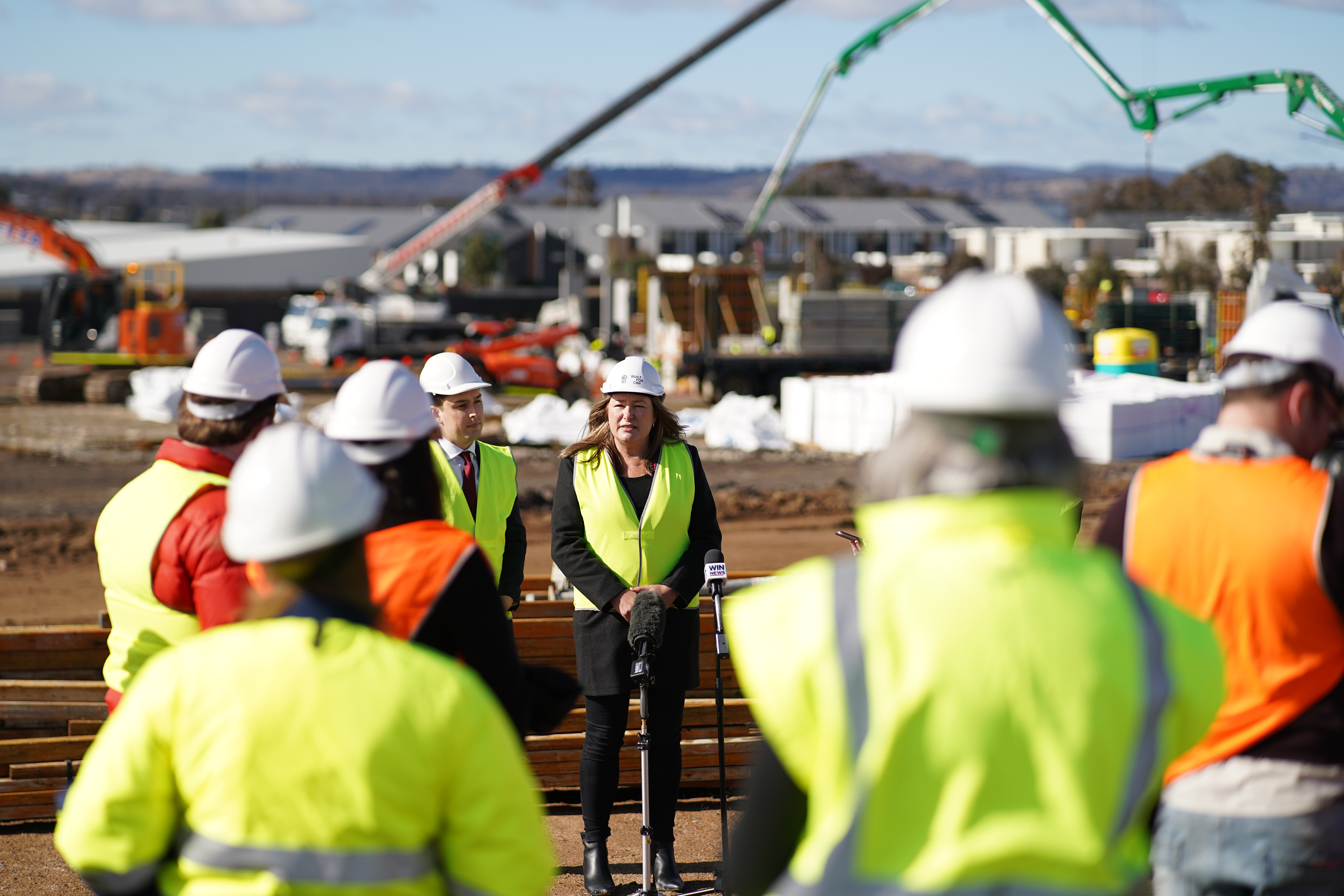 The Minister for Education provides comment to the media in front of construction workers