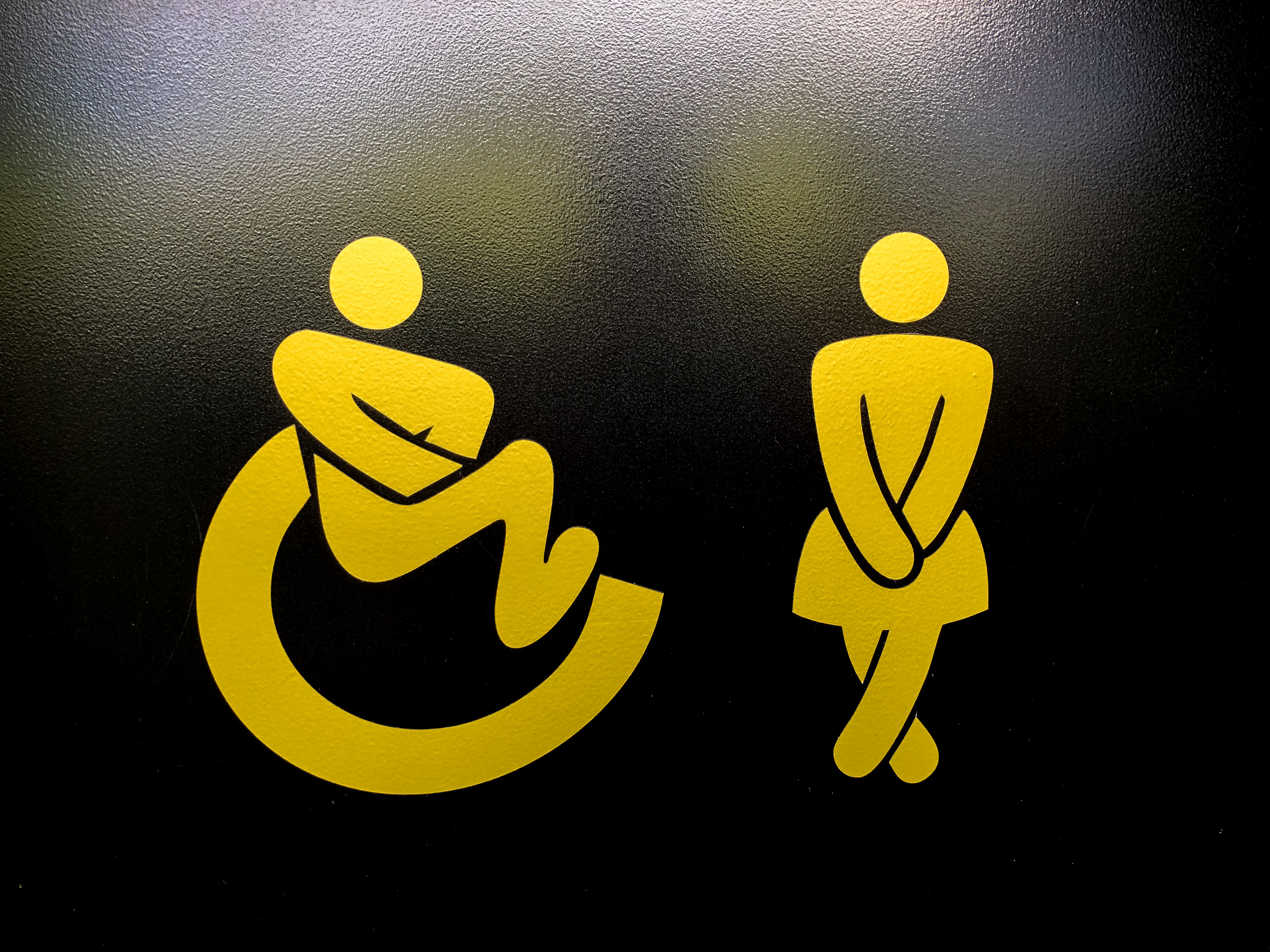 an ambulant logo and female bathroom logo crossing his legs busting for the bathroom