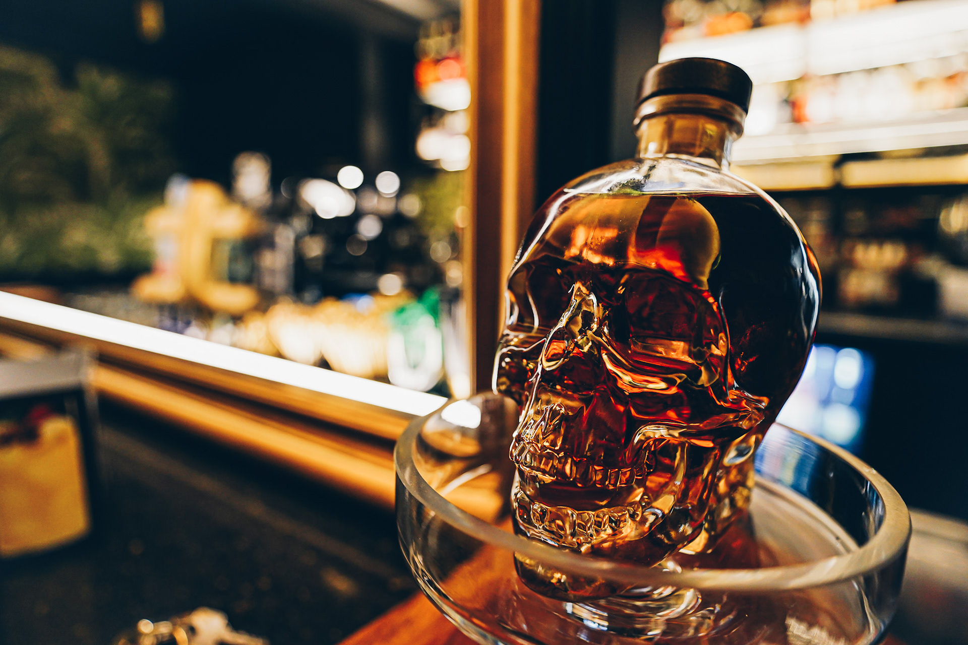 A glossy skull liquor bottle filled with dark alcohol 