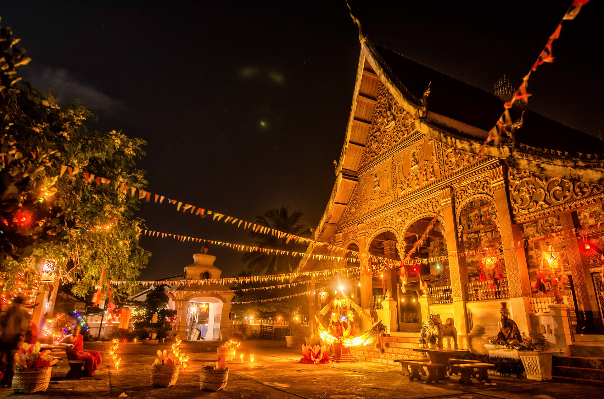 Templo iluminado por velas e ornamentos. Temple decorated by candles and ornaments. Documentary photographic project about the Fire Boat Festival in Laos. Lanter, culture, tradition, ornament, temple, monk, buddha, buddhism, night, village, story, festa. celebração. Projeto de fotografia documental sobre o Festival do Barco de Fogo no Laos. Lanterna, cultura, tradição, templo, monge, budismo, ornamento, noite, vila, história, party, celebration.