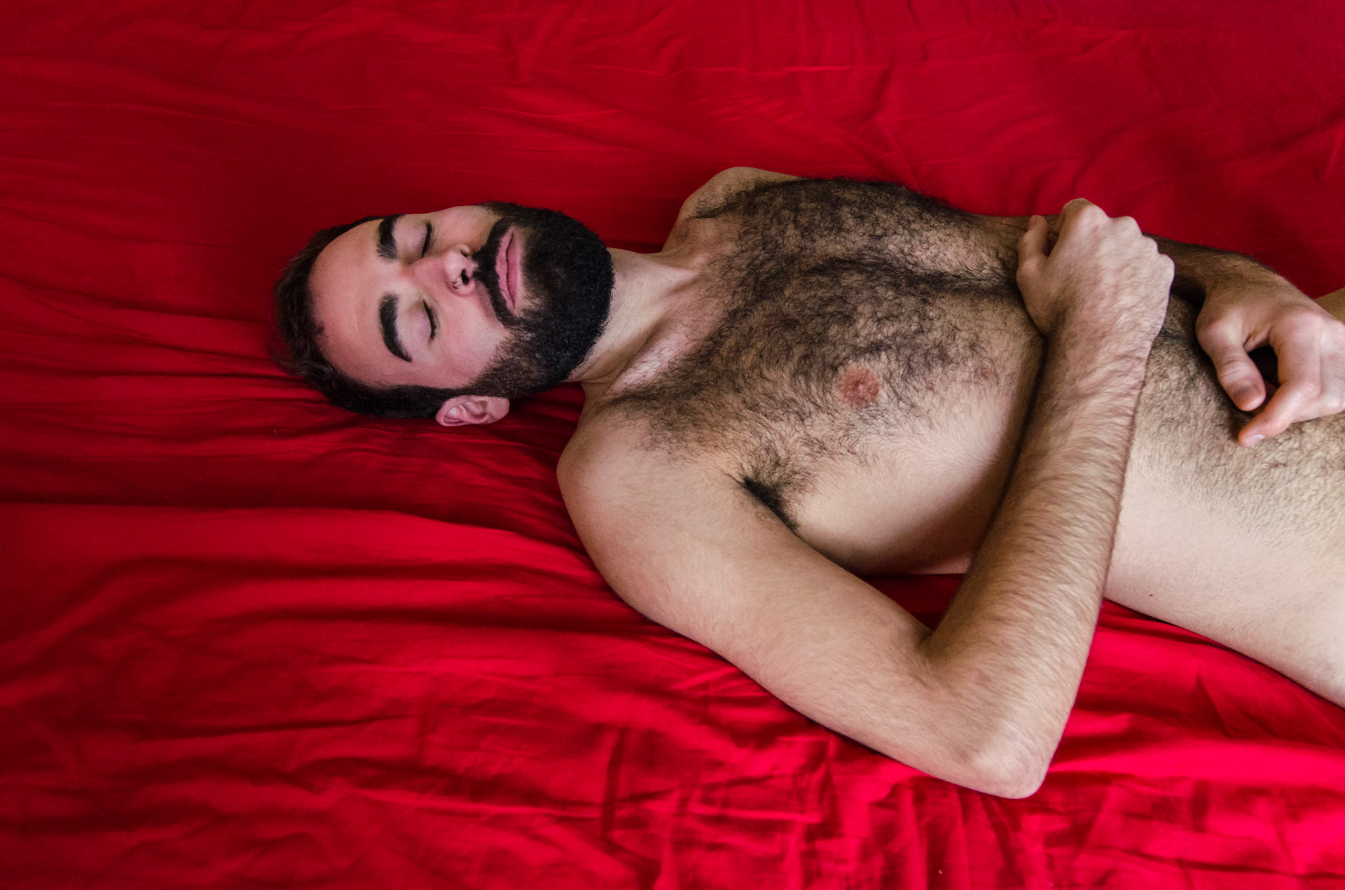 Naked hairy man lies on red bed. Portrait, beard, boudoir, retrato, homen, nu, barba, pelos, chest, sleep, dormindo, masculino